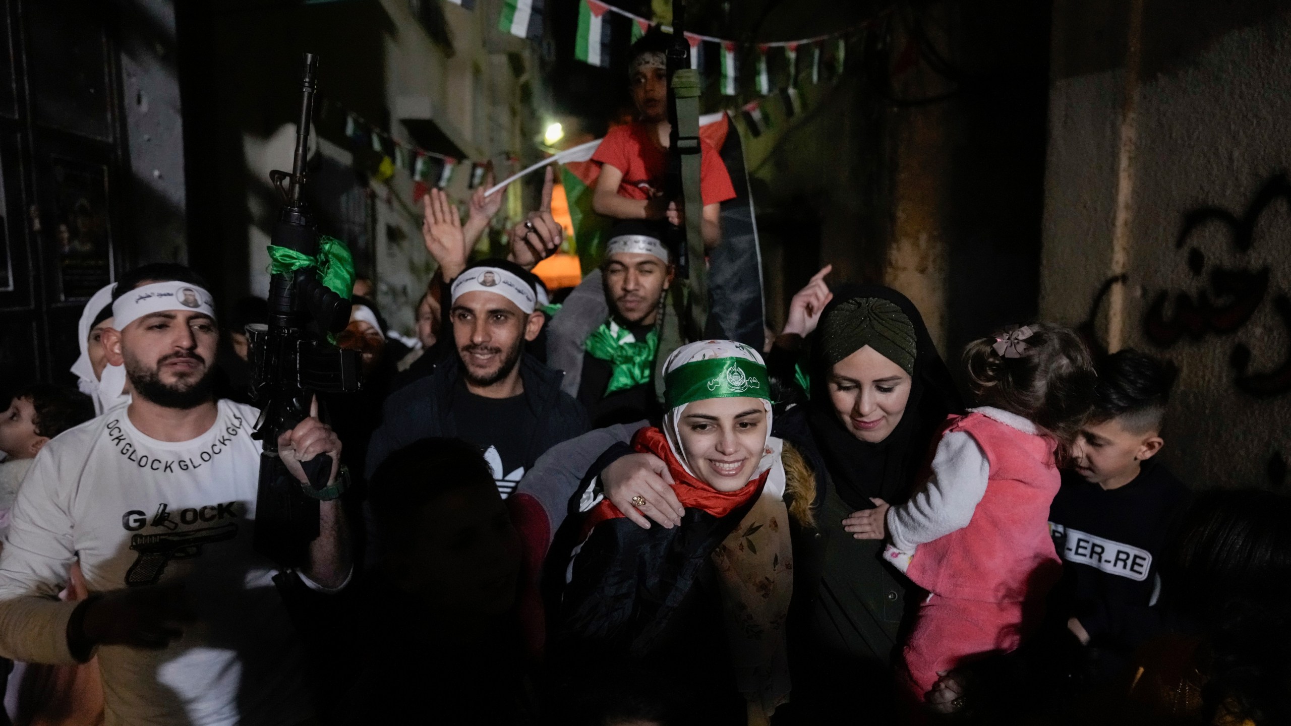 Aseel al-Titi, wearing a Hamas headband, a former Palestinian prisoner who was released by the Israeli authorities, is greeted by friends and family members in Balata, a Palestinian refugee camp in Nablus, West Bank, Friday, Nov. 24, 2023. (AP Photo/Majdi Mohammed)