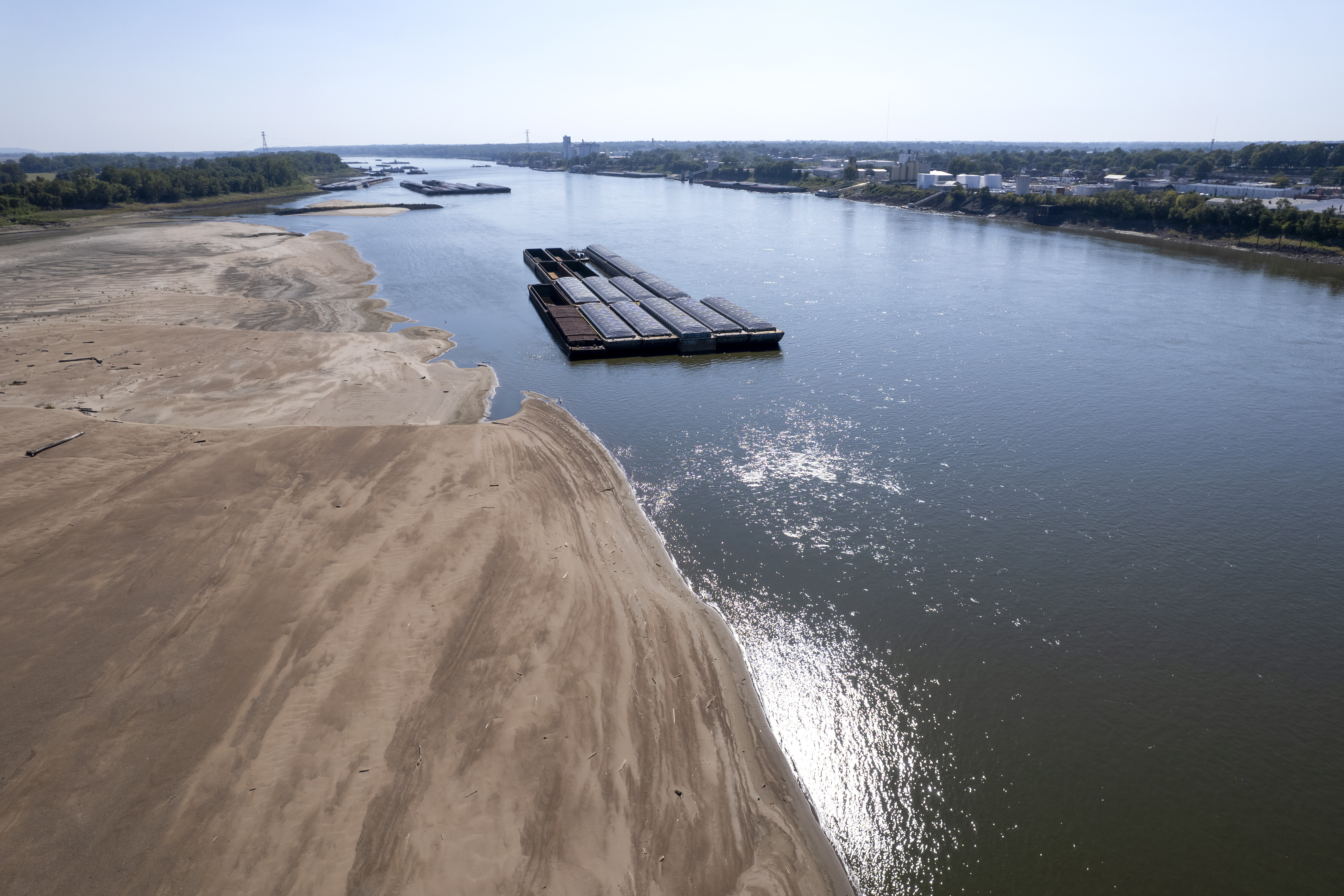 FILE - Barges float in the Mississippi River as a portion of the riverbed is exposed, on Sept. 15, 2023, in St. Louis. The U.N. weather agency is reporting that 2023 was the driest year in more than three decades for the world's rivers, as the record-hot year underpinned a drying up of water flows and contributed to prolonged droughts in some places. (AP Photo/Jeff Roberson, File)