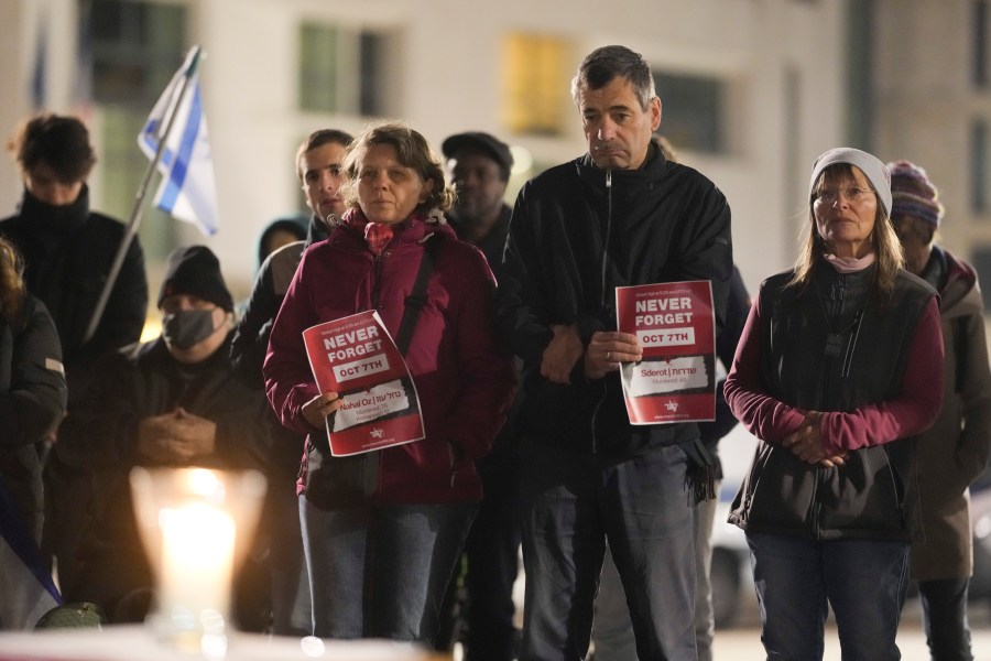 People attend the reading the names of the victims of the Hamas attack on Israel during a commemoration to mark the first anniversary of the attack, at the Brandenburg Gate in Berlin, Germany, Monday, Oct. 7, 2024. (AP Photo/Markus Schreiber)