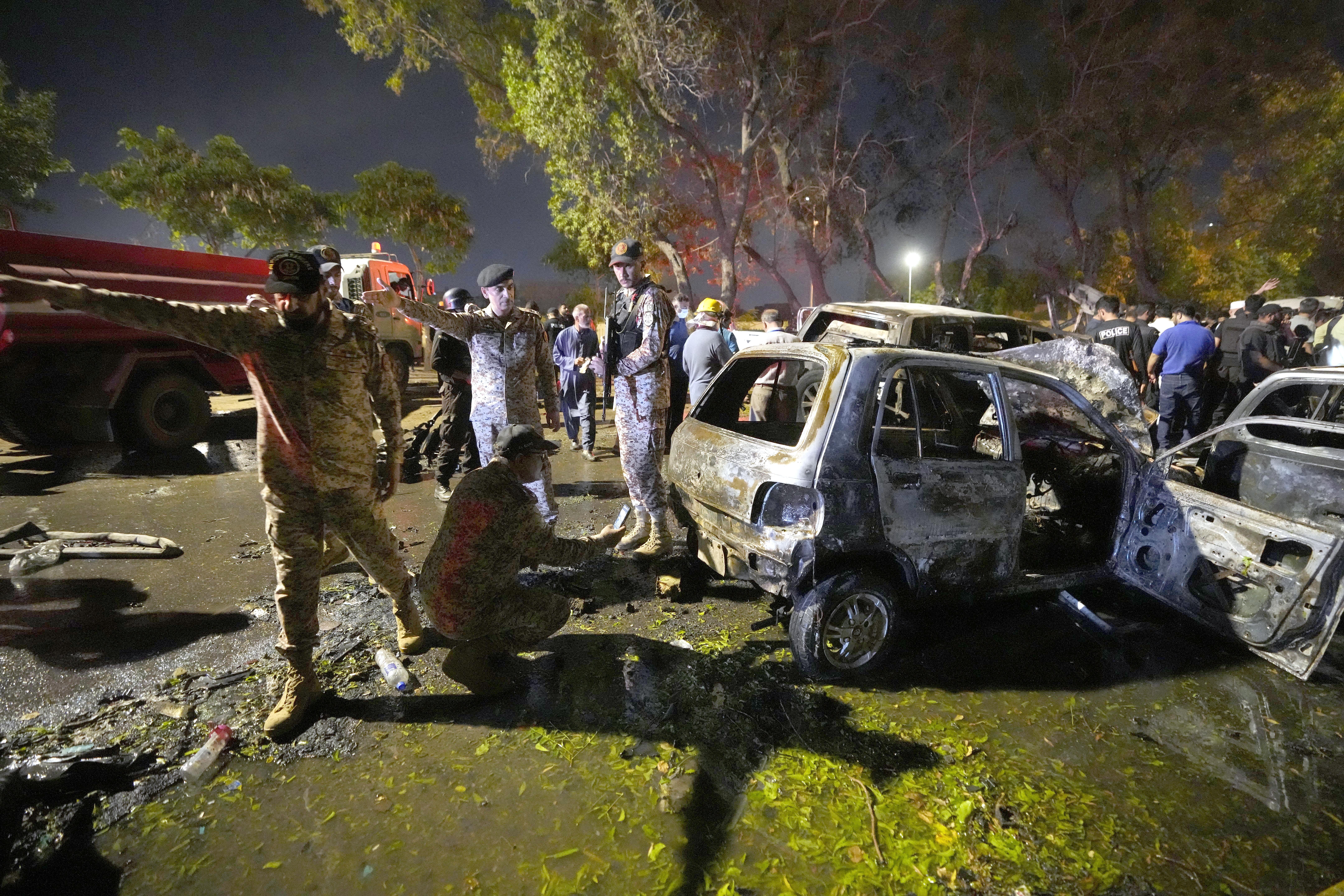 Security officials examine damage cars at the site of an explosion that caused injures and destroyed vehicles at outside the Karachi airport, Pakistan, Monday, Oct. 7, 2024. (AP Photo/Fareed Khan)