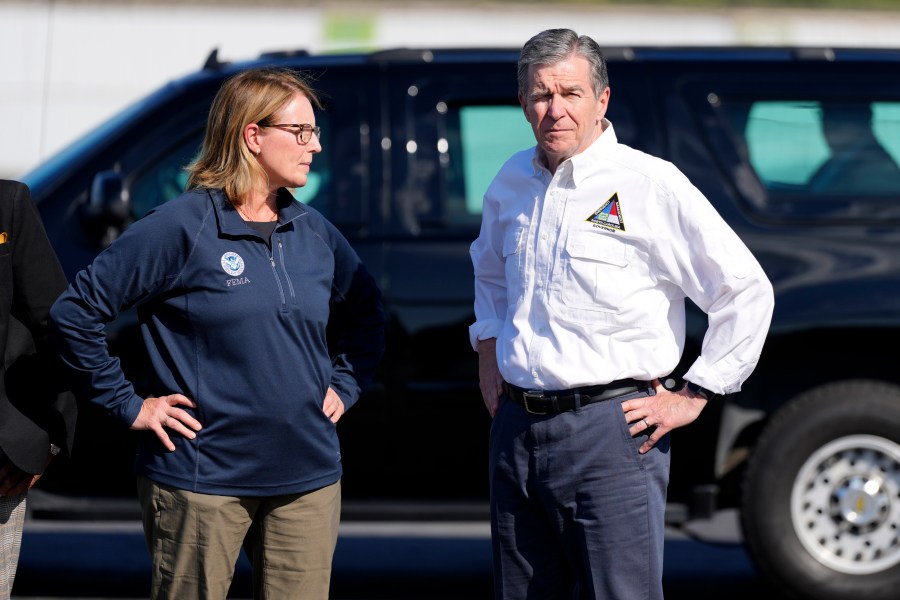 FILE- North Carolina Gov. Roy Cooper, right, and Deanne Criswell, Administrator of the U.S. Federal Emergency Management Agency, await the arrival of Democratic presidential nominee Vice President Kamala Harris for a briefing on the damage from Hurricane Helene, at Charlotte Douglas International Airport, Oct. 5, 2024, in Charlotte, N.C. (AP Photo/Chris Carlson, file)