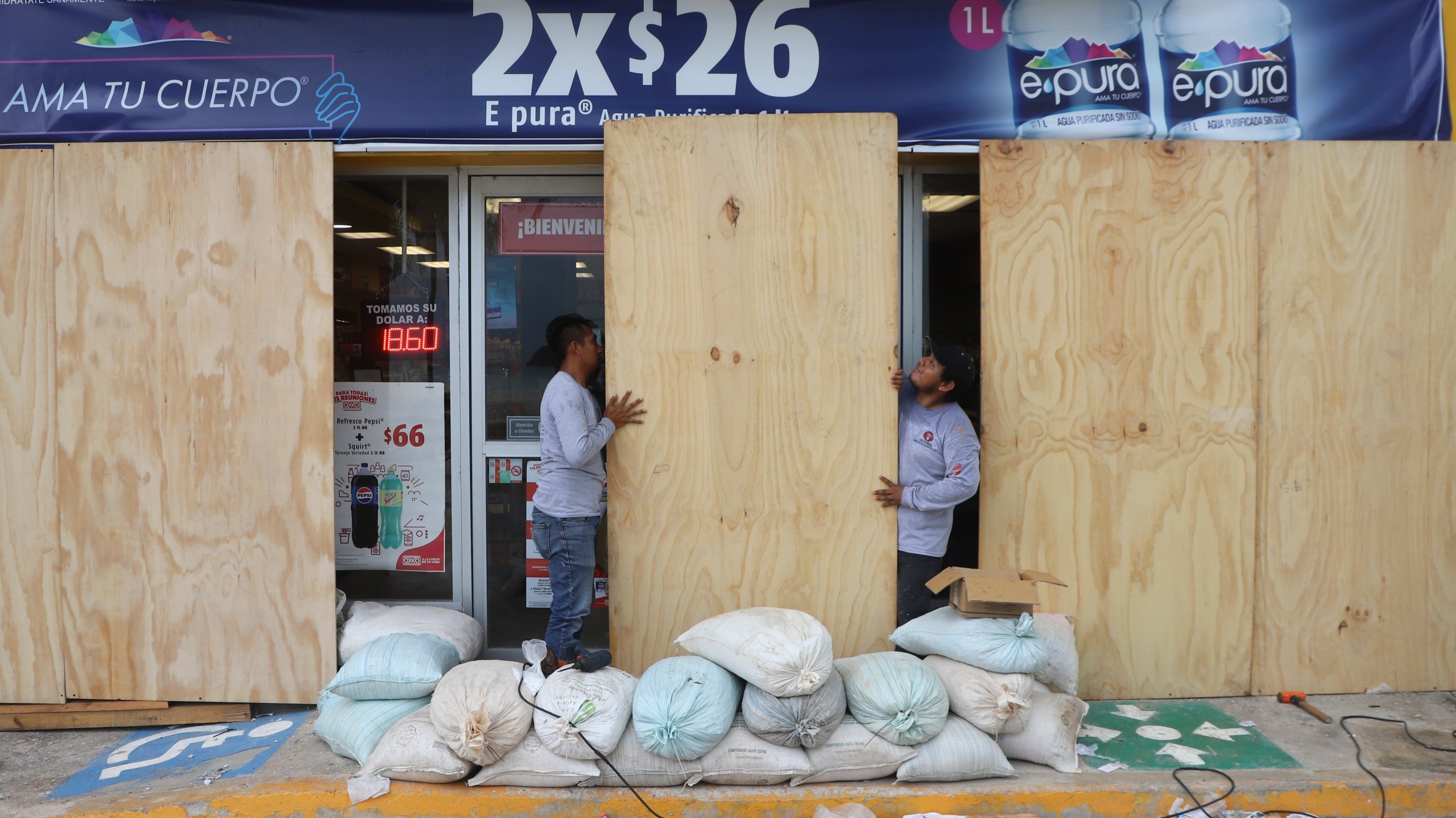 FILE - Workers board up a grocery store to protect it from Hurricane Milton, in Progreso, Yucatan state, Mexico, Oct. 7, 2024. (AP Photo/Martin Zetina, File)