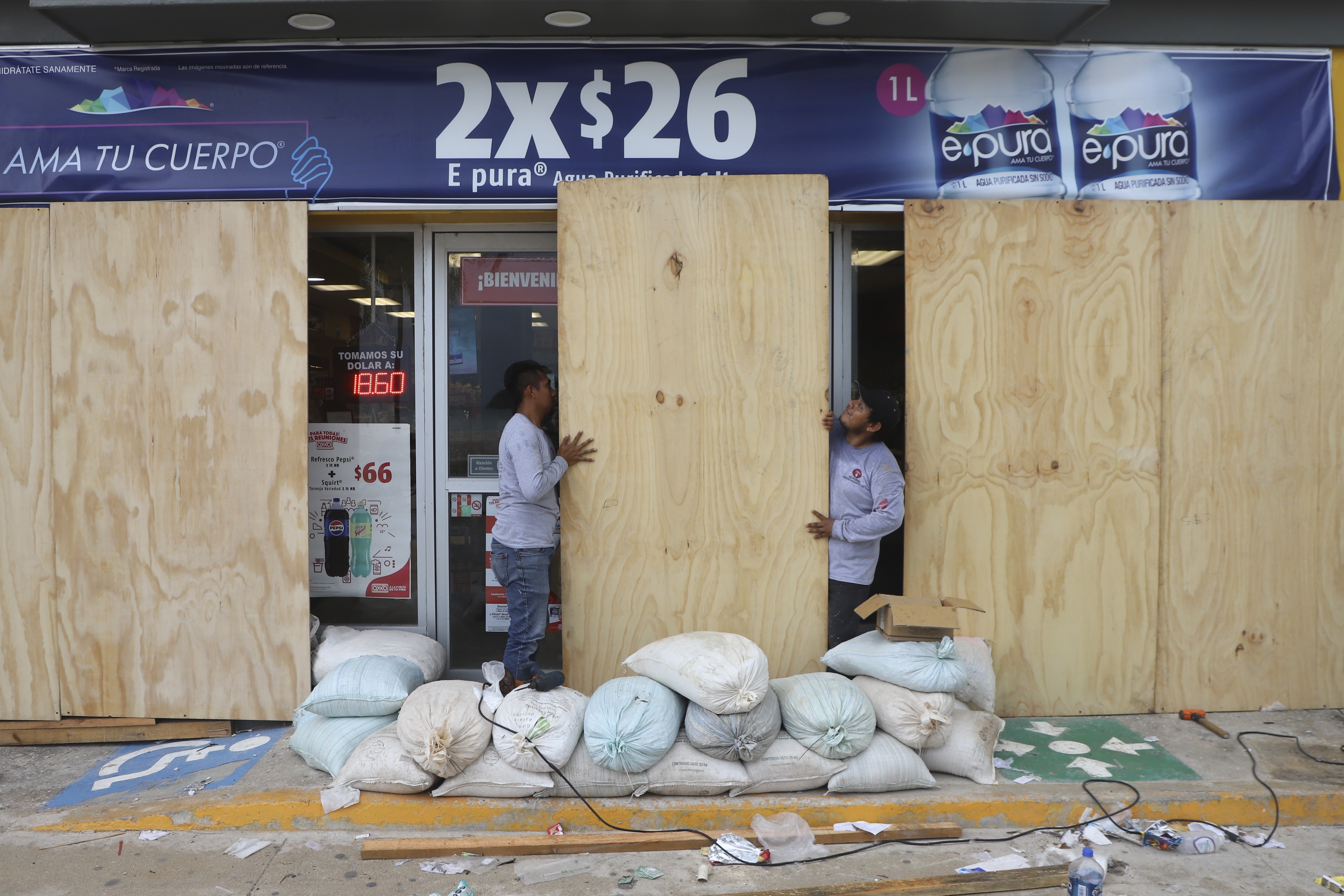 FILE - Workers board up a grocery store to protect it from Hurricane Milton, in Progreso, Yucatan state, Mexico, Oct. 7, 2024. (AP Photo/Martin Zetina, File)