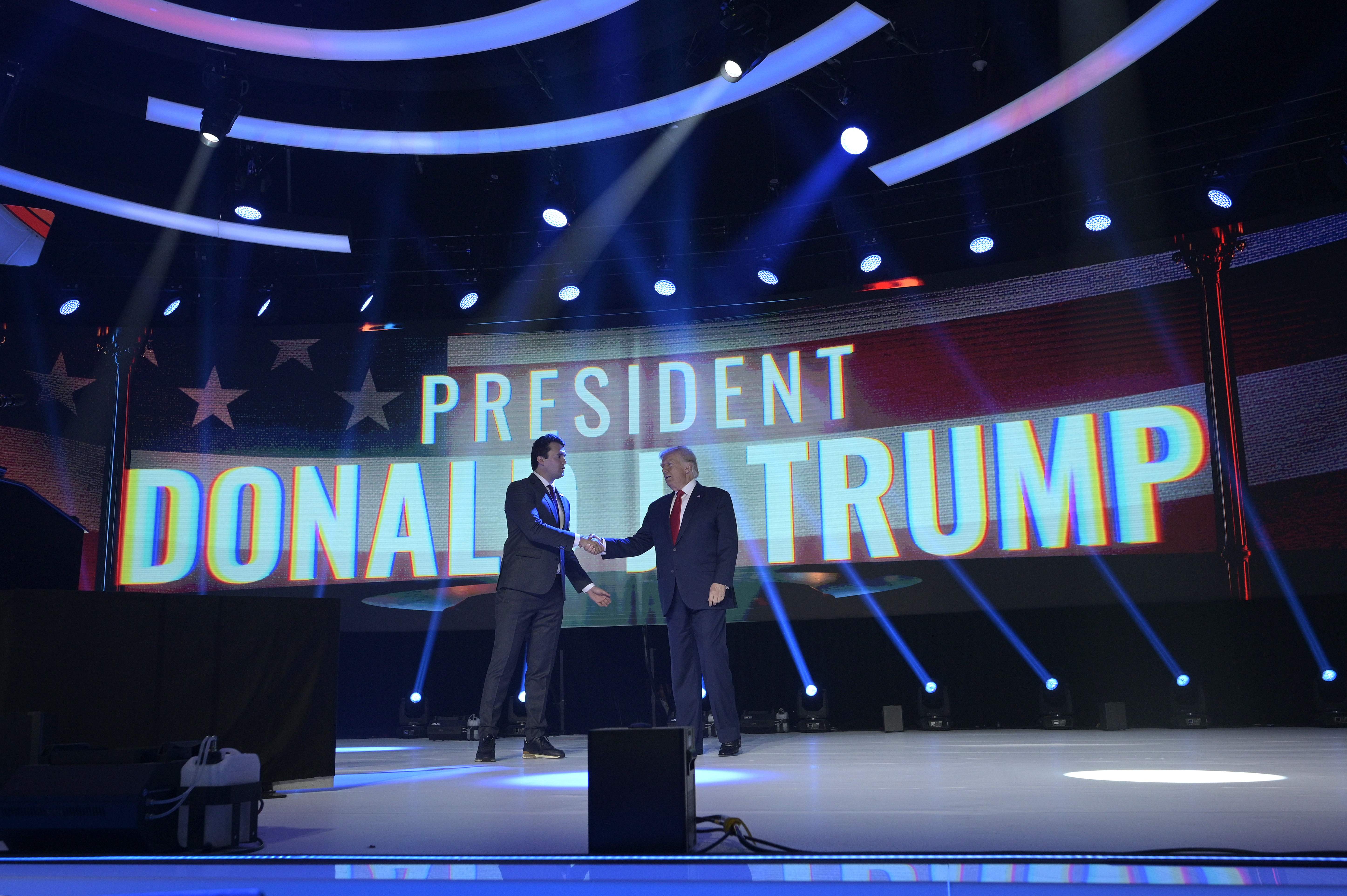 FILE - Former President Donald Trump, right, shakes hands with Turning Point CEO Charlie Kirk before speaking during the Turning Point USA Student Action Summit, Saturday, July 23, 2022, in Tampa, Fla. (AP Photo/Phelan M. Ebenhack, File)