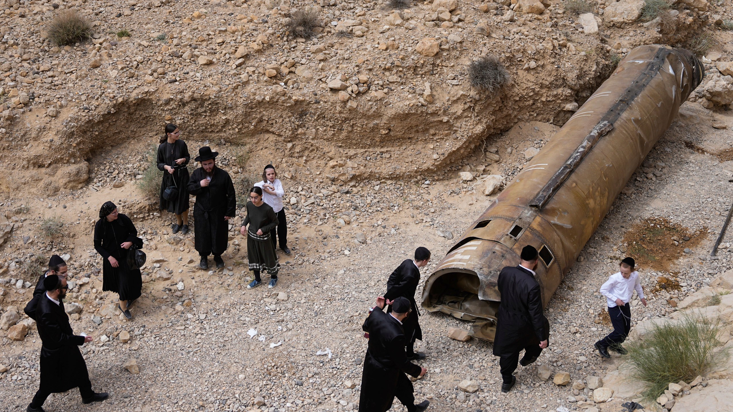 FILE - Ultra-Orthodox Jews inspect the debris of what is believed to be an intercepted Iranian missile near the city of Arad, southern Israel, Sunday, April 28, 2024. (AP Photo/ Ohad Zwigenberg, File)