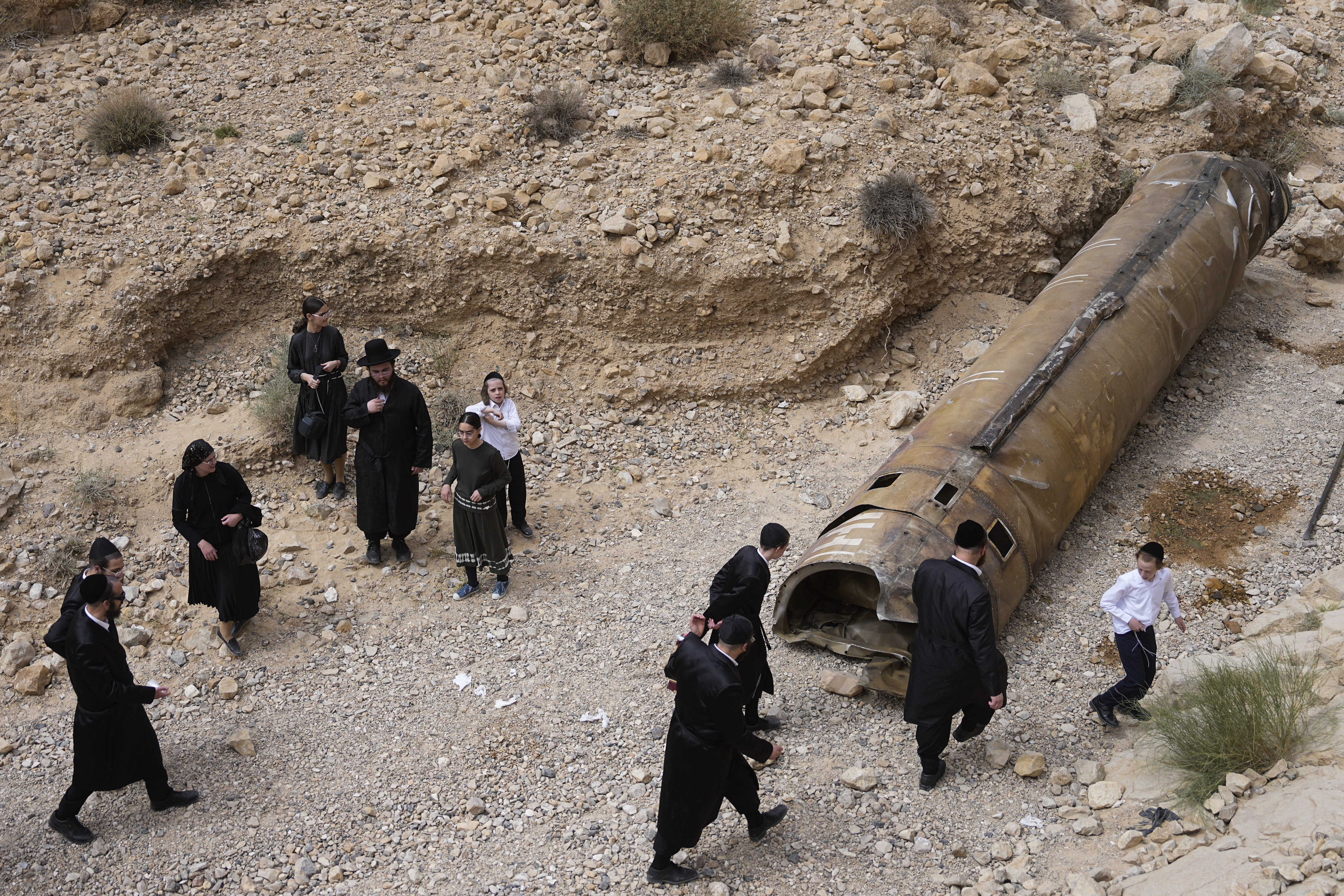 FILE - Ultra-Orthodox Jews inspect the debris of what is believed to be an intercepted Iranian missile near the city of Arad, southern Israel, Sunday, April 28, 2024. (AP Photo/ Ohad Zwigenberg, File)