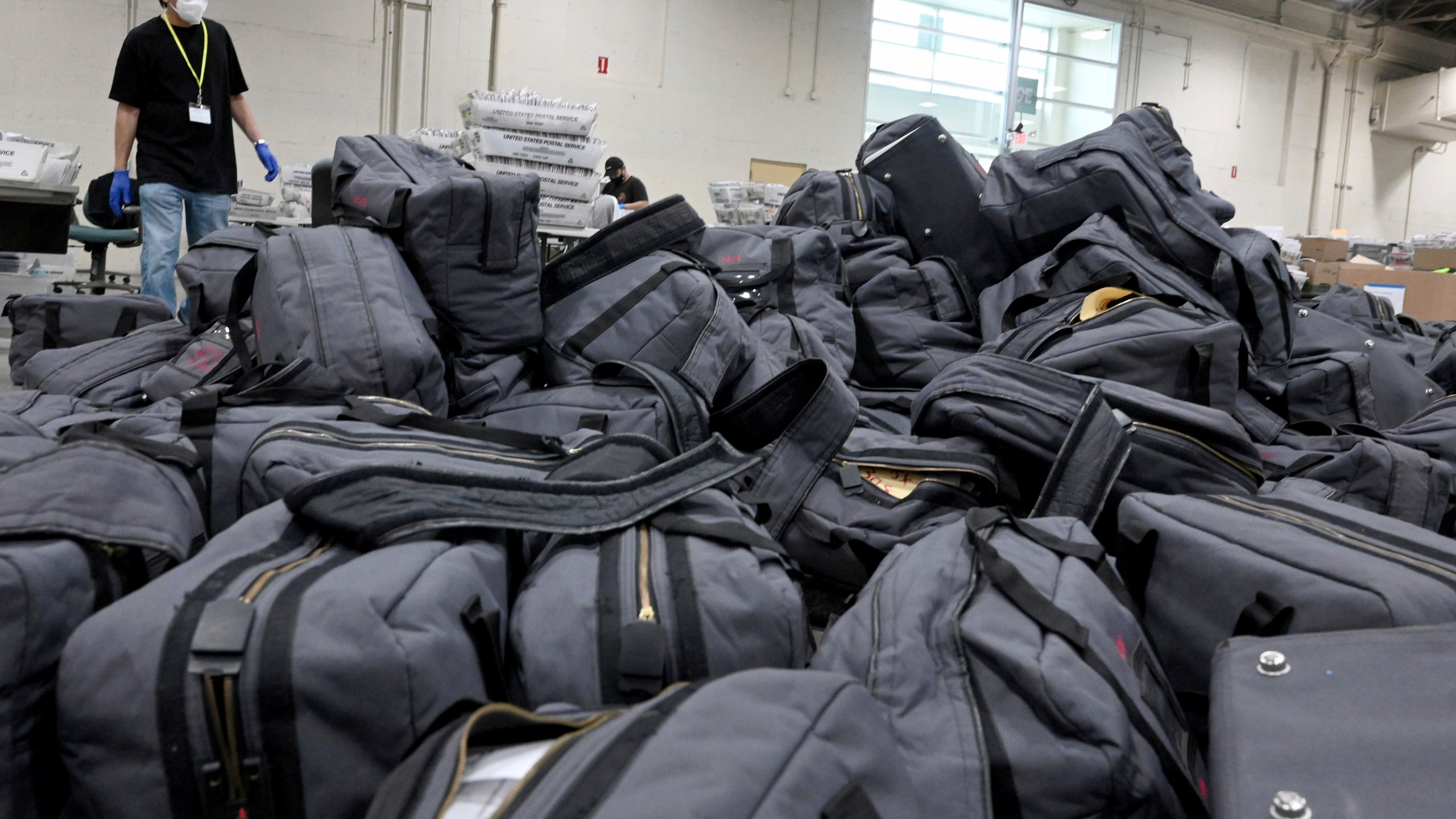 FILE - A worker prepares to take bags of ballots to be sorted and processed by the Los Angeles County Registrar at the temporary building at the Pomona Fairplex in Pomona, Calif., Thursday, Nov. 5, 2020. (Keith Birmingham/The Orange County Register via AP)