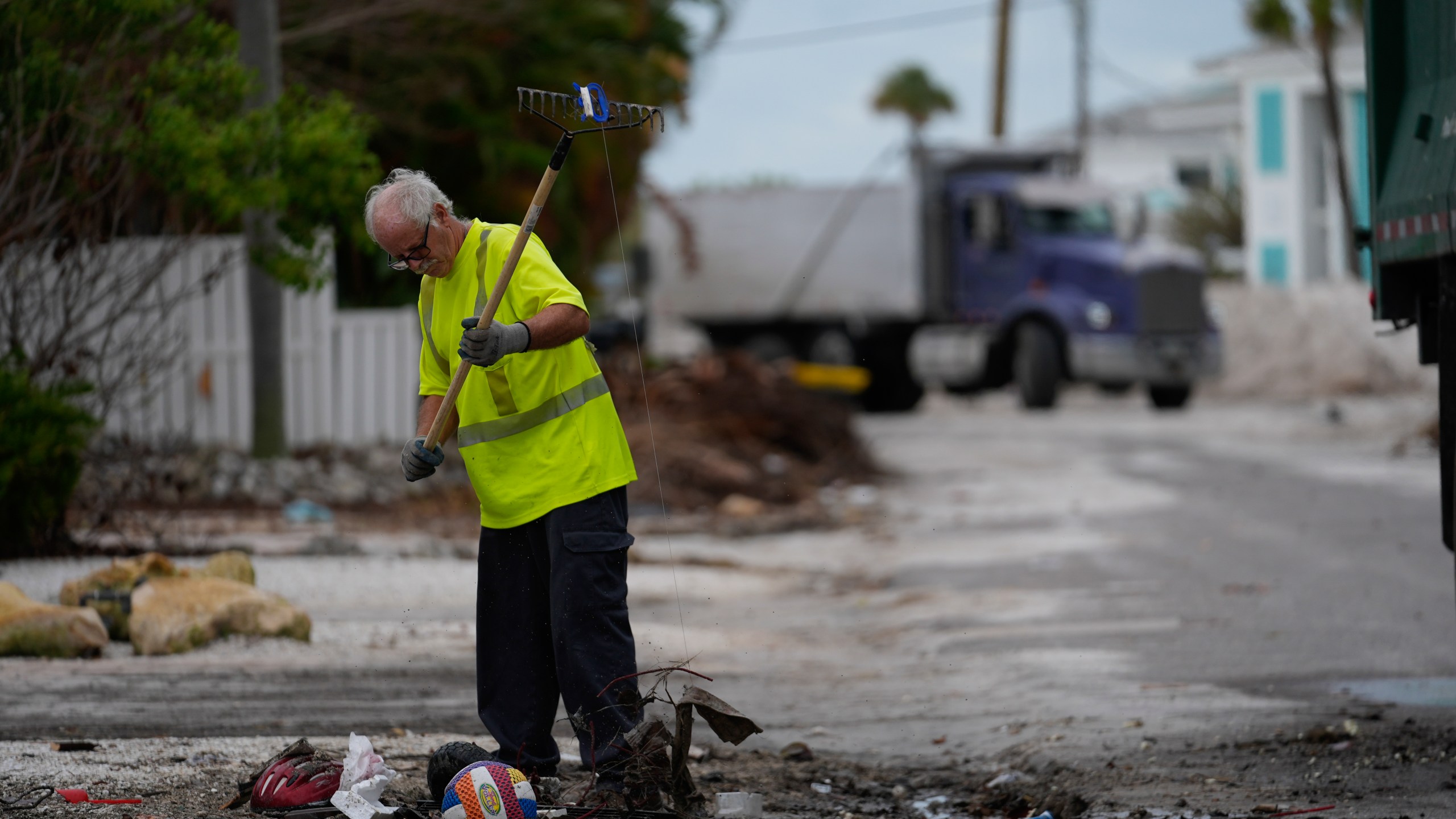 Teams work to clean up piles of debris from Hurricane Helene flooding ahead of the arrival of Hurricane Milton, in Holmes Beach on Anna Maria Island, Fla., Tuesday, Oct. 8, 2024. (AP Photo/Rebecca Blackwell)