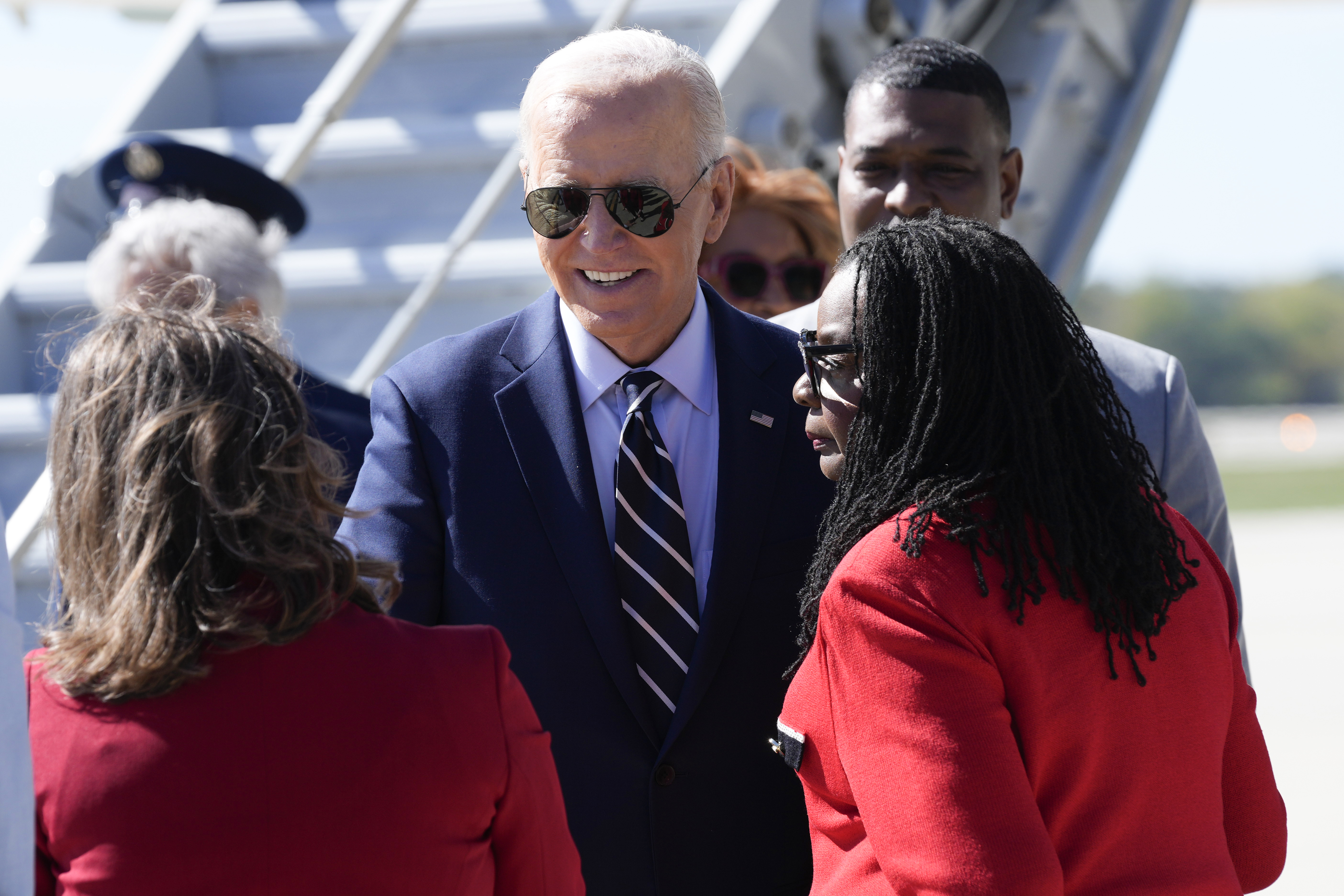 President Joe Biden is greeted by Rep. Gwen Moore, D-Wis., right, and other officials after arriving at Milwaukee Mitchell International Airport in Milwaukee, Tuesday, Oct. 8, 2024. (AP Photo/Susan Walsh)