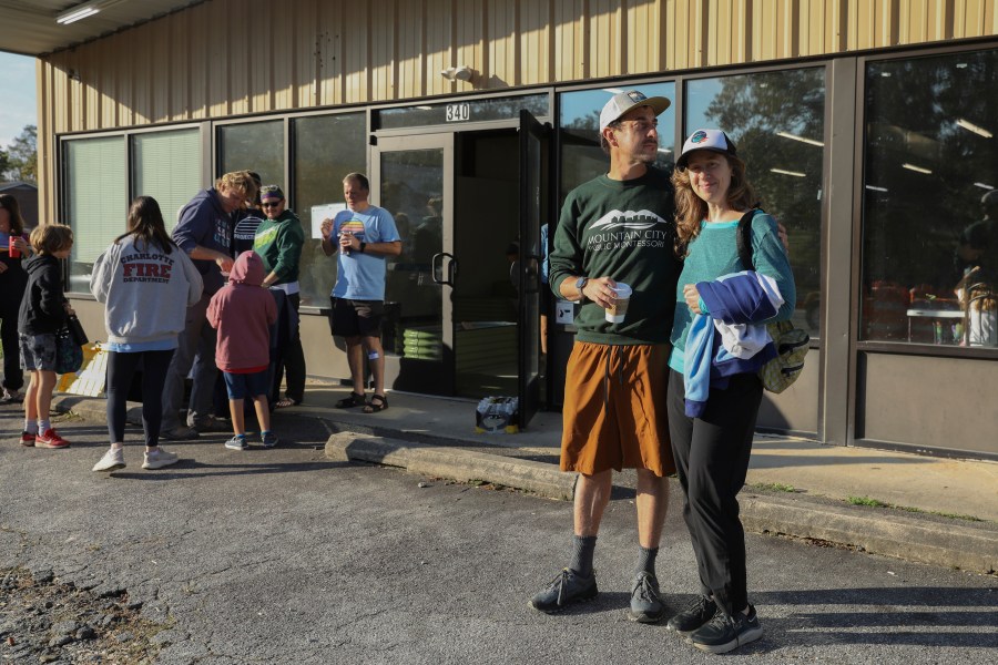 Max and Aviva Weissman stand outside the Boys and Girls Club of Transylvania County in Brevard, N.C., Tuesday, Oct. 8, 2024 after dropping off their kids at Project Camp. (AP Photo/Gabriela Aoun Angueira)