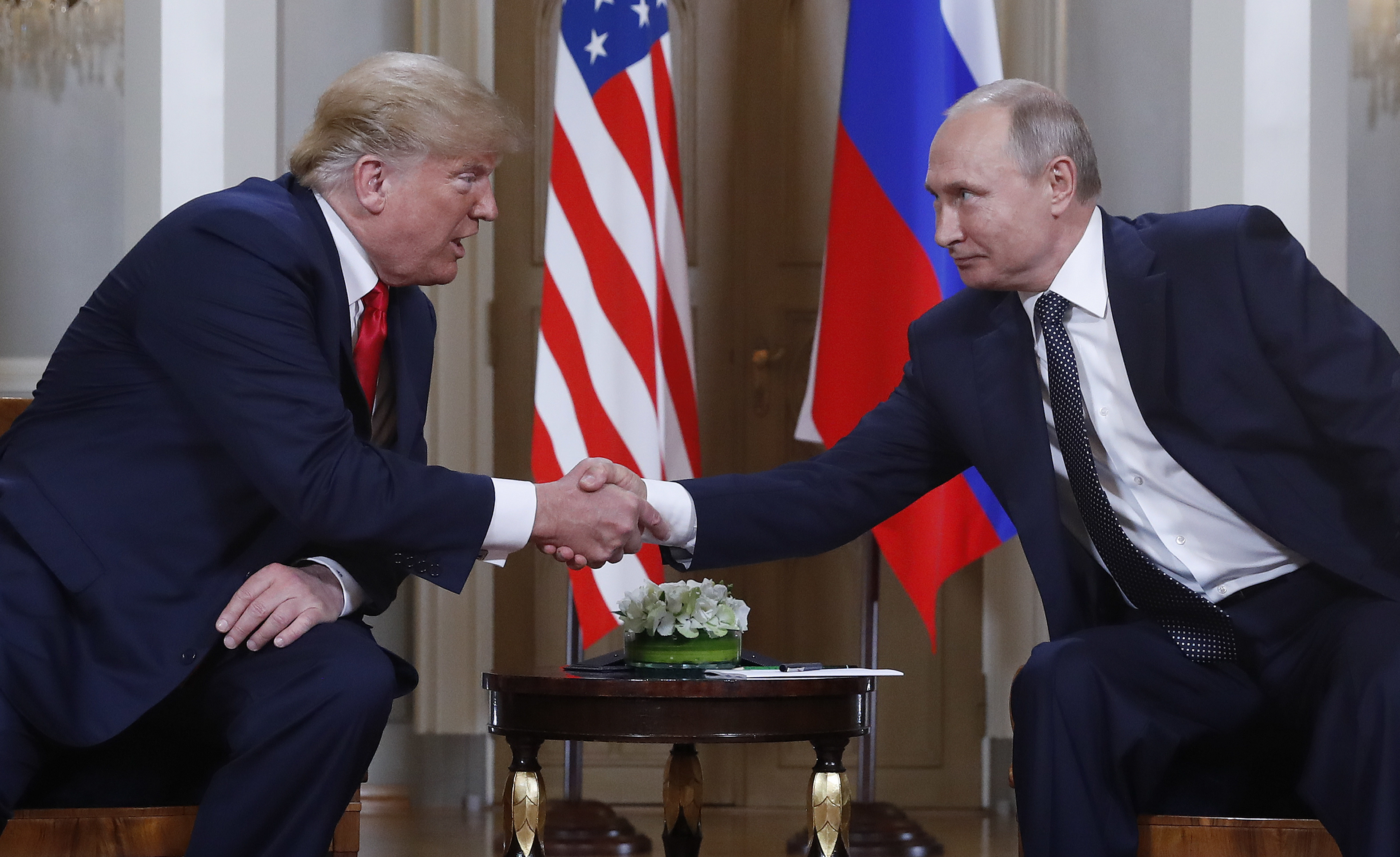 FILE - U.S. President Donald Trump, left, and Russian President Vladimir Putin, right, shake hands at the beginning of a meeting at the Presidential Palace in Helsinki, Finland, July 16, 2018. (AP Photo/Pablo Martinez Monsivais, File)