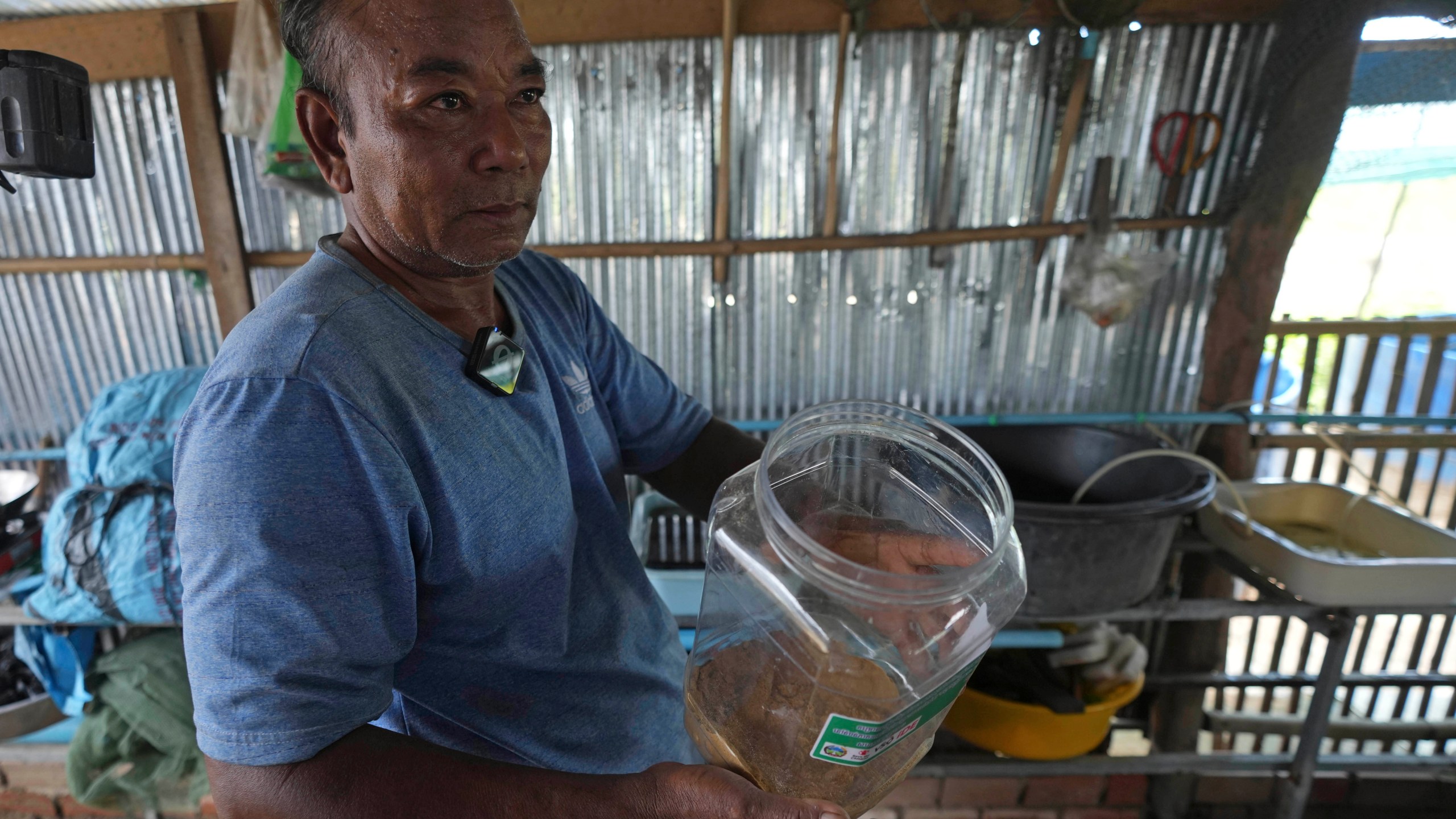 Eel farmer Em Phat, 53, works in his eel rearing place at Tonle Sap complex, north of Phnom Penh, Cambodia, Wednesday, July 31, 2024. (AP Photo/Heng Sinith)