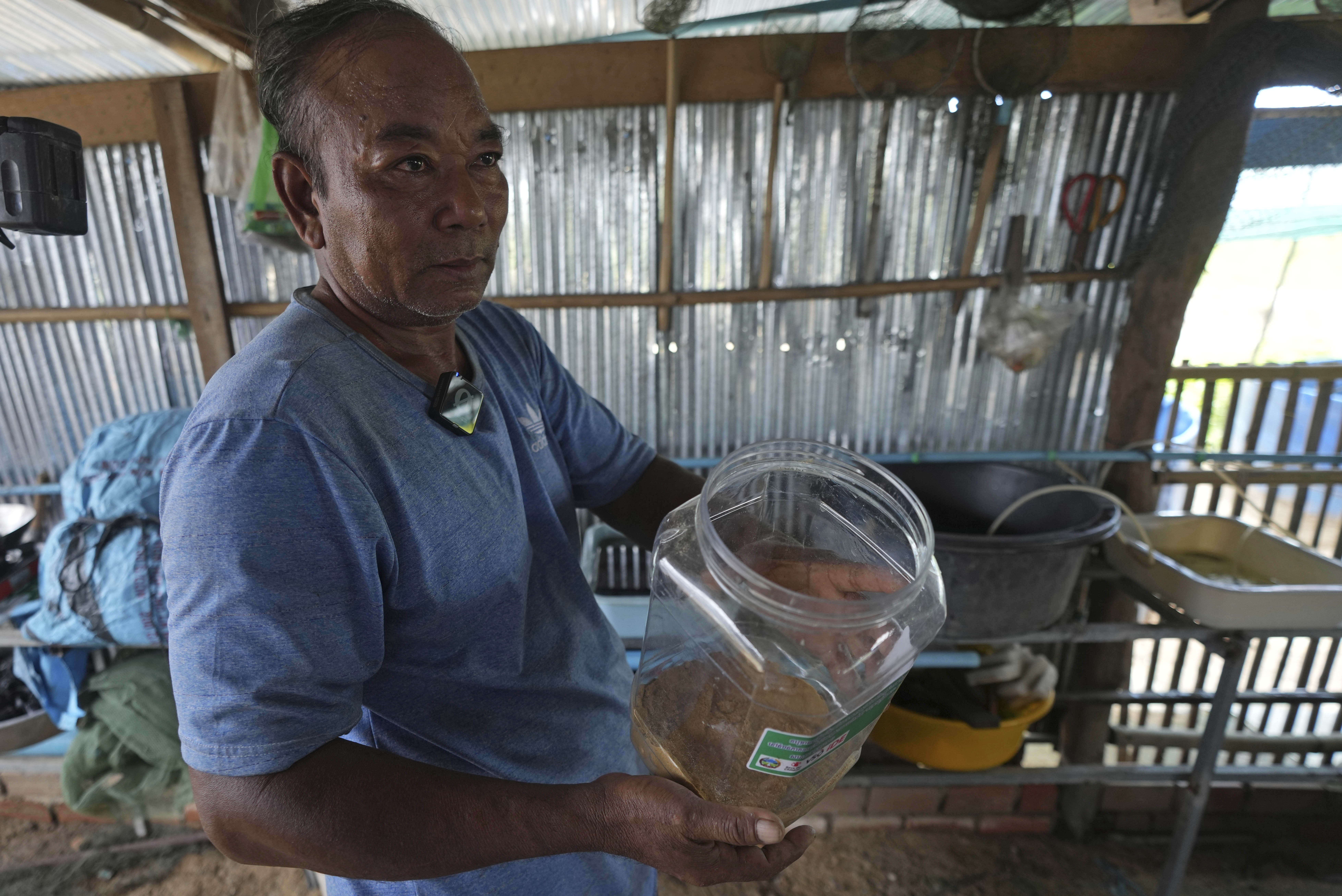 Eel farmer Em Phat, 53, works in his eel rearing place at Tonle Sap complex, north of Phnom Penh, Cambodia, Wednesday, July 31, 2024. (AP Photo/Heng Sinith)