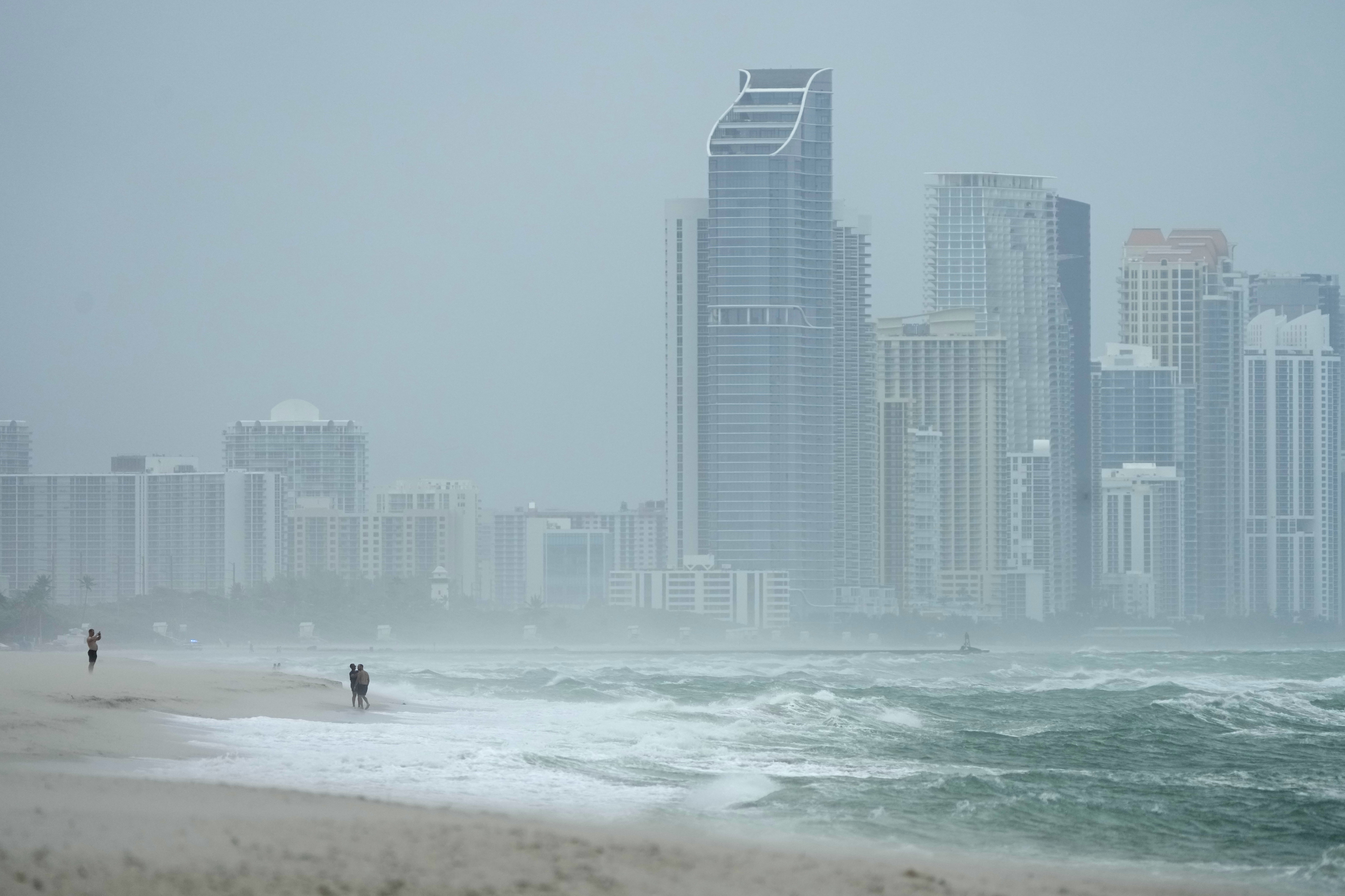 The city of Sunny Isles Beach, Fla., is seen from Surfside, Fla., as the outer bands of Hurricane Milton kick up the sand, Wednesday, Oct. 9, 2024. (AP Photo/Wilfredo Lee)