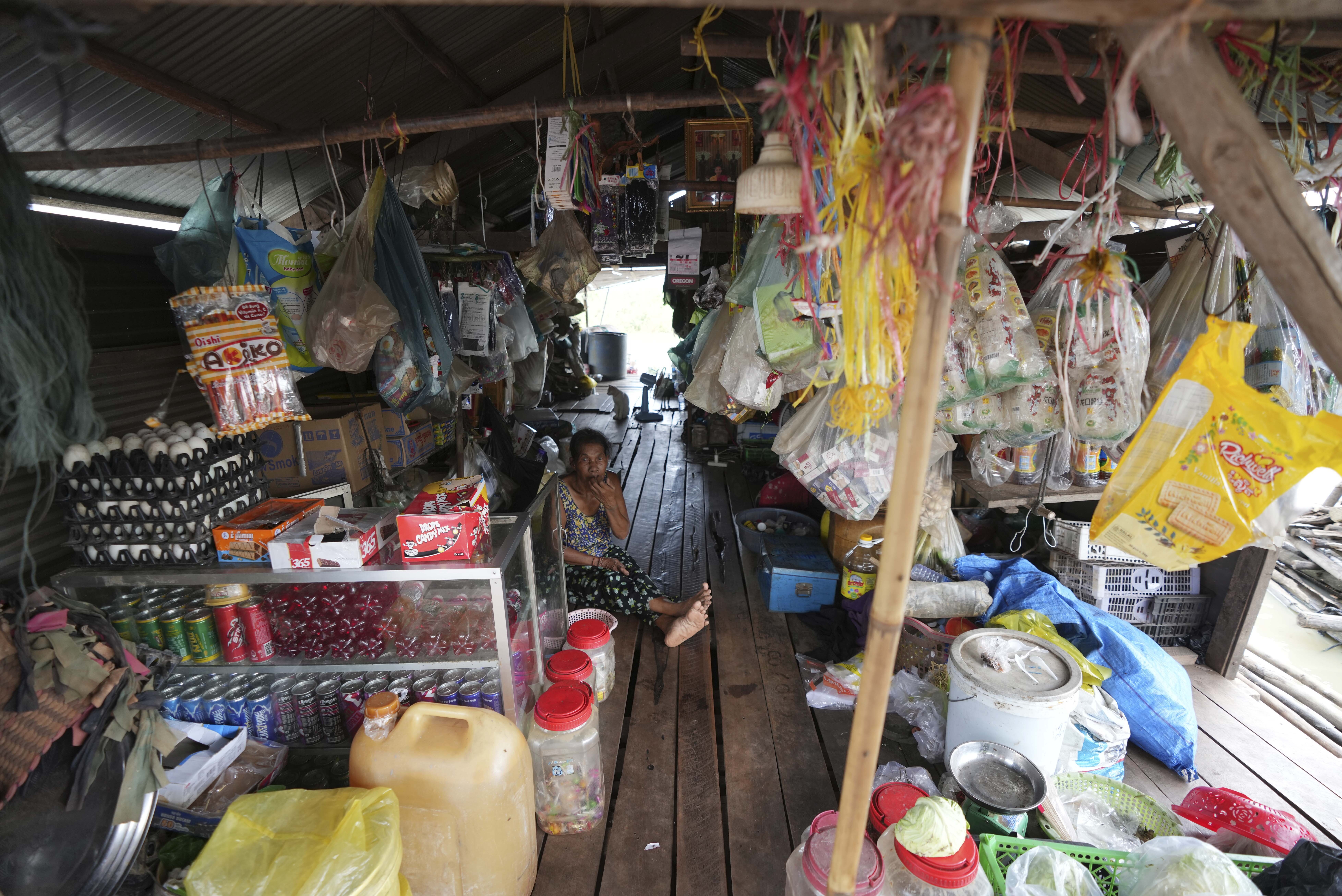 A local vendor sits at her grocery store at a floating village by the Tonle Sap in Kampong Chhnang province, Cambodia, Thursday, Aug. 1, 2024, (AP Photo/Heng Sinith)