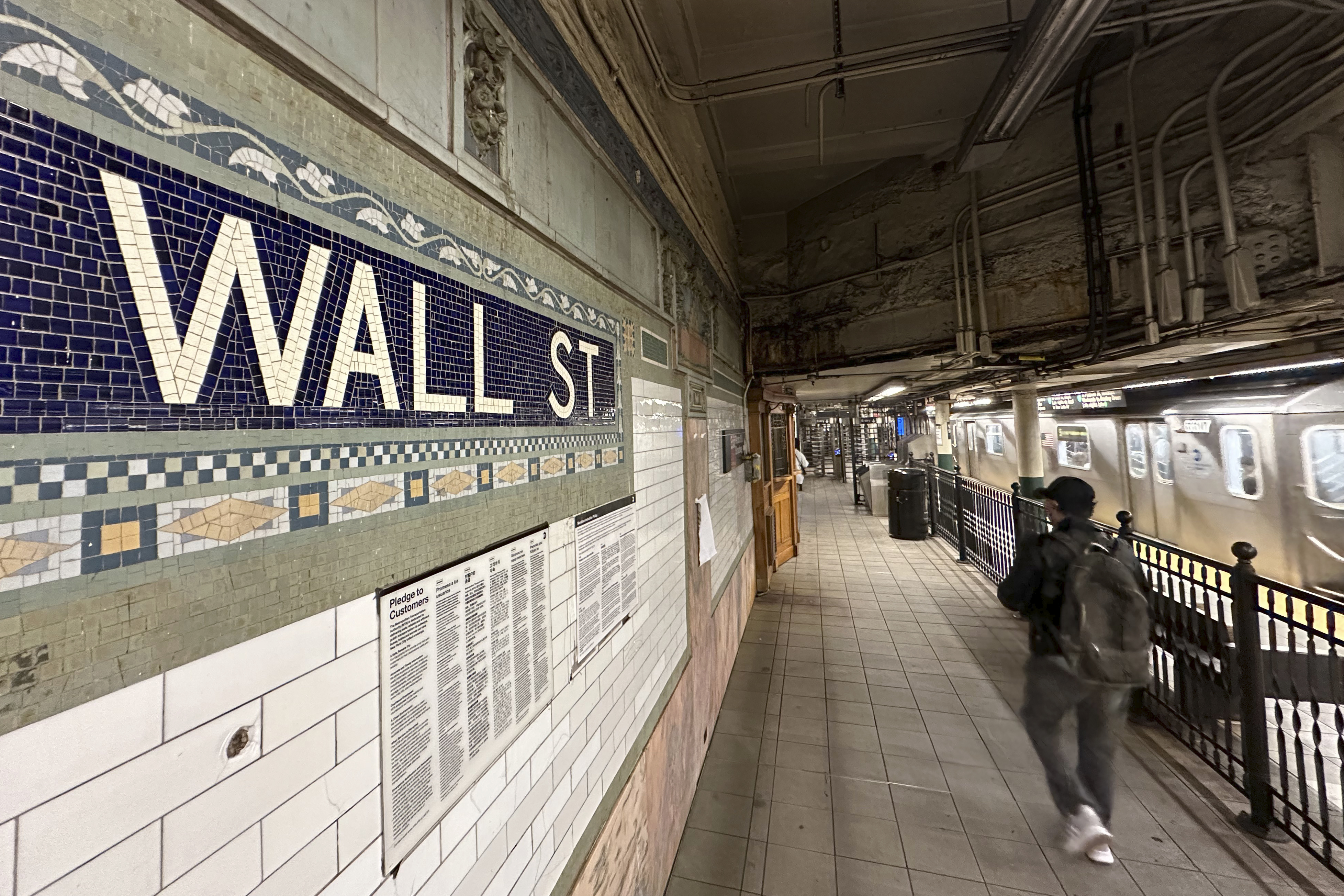 Passengers leave a train at the Wall St. subway station in New York's Financial District on Wednesday, Oct. 9, 2024. (AP Photo/Peter Morgan)