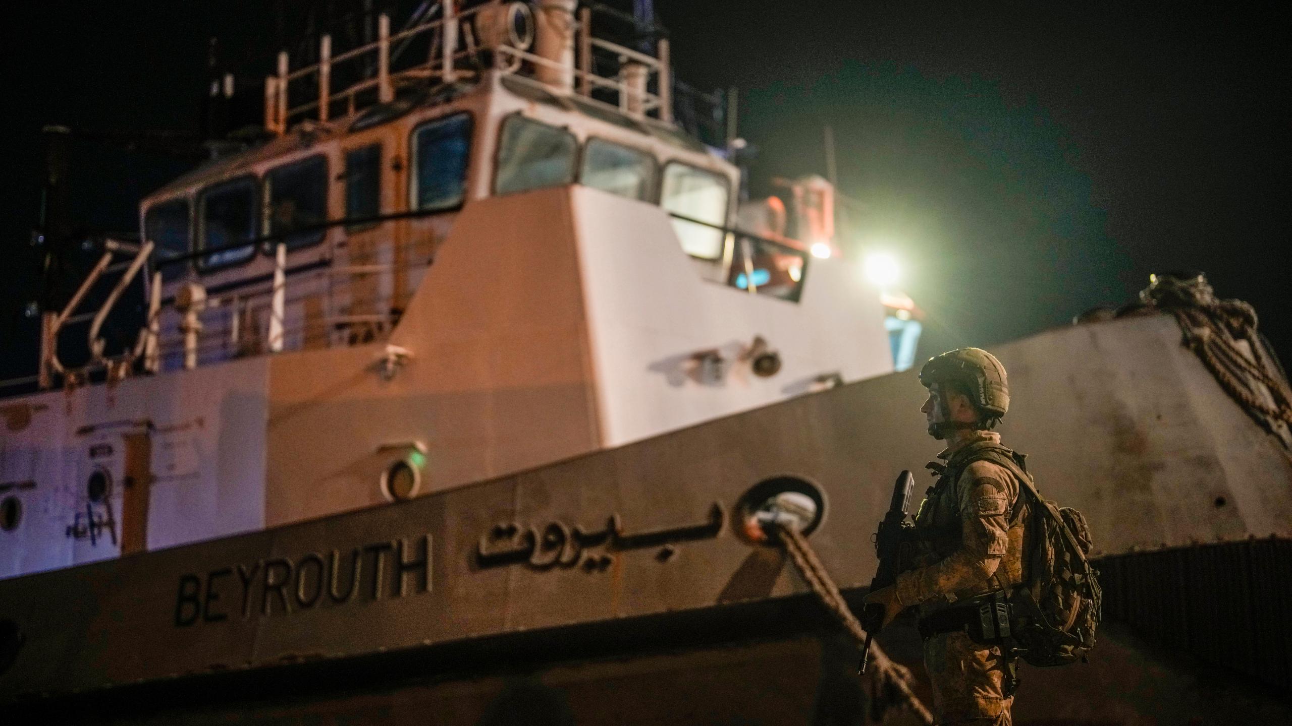 A Turkish security personnel stands guard next to Turkish military ships preparing to evacuate citizens from Lebanon to Turkey, in Beirut port, Wednesday, Oct. 9, 2024. (AP Photo/Emrah Gurel)