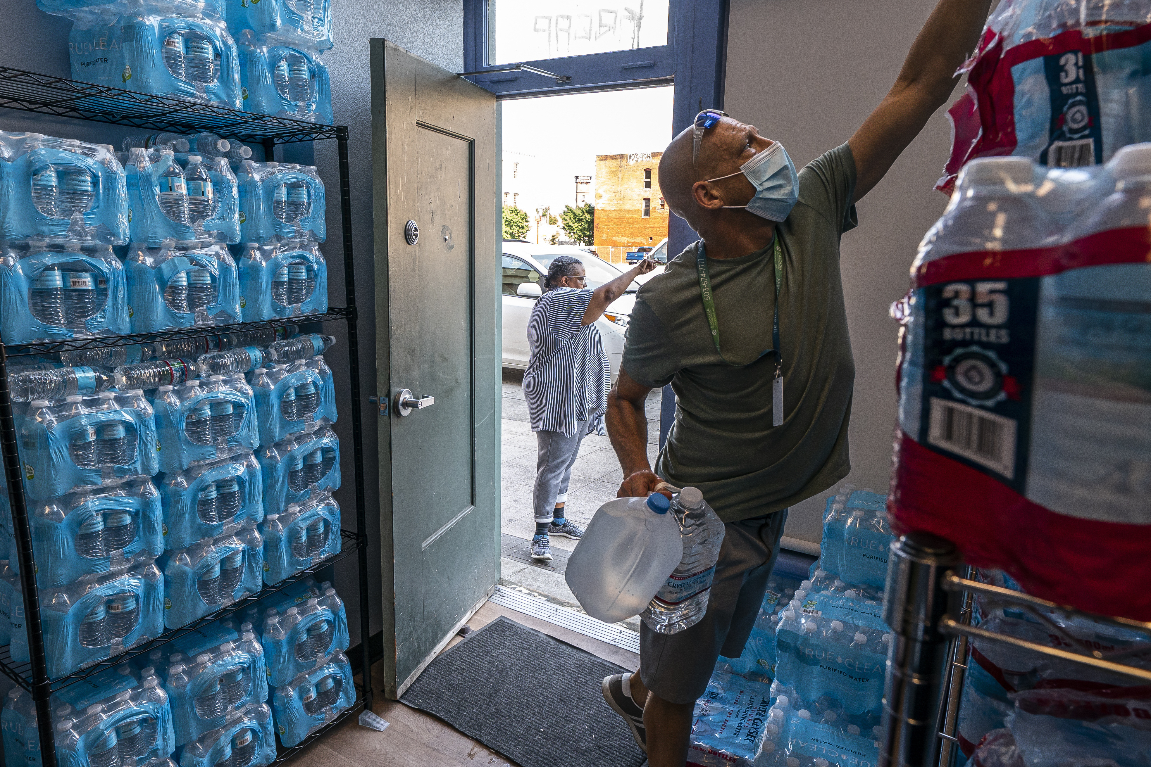 FILE - Chris Cowan with Cascadia Behavioral Healthcare's street outreach team loads water and other cooling supplies before visiting homeless camps, Aug. 12, 2021, in Portland, Ore. (AP Photo/Nathan Howard, File)