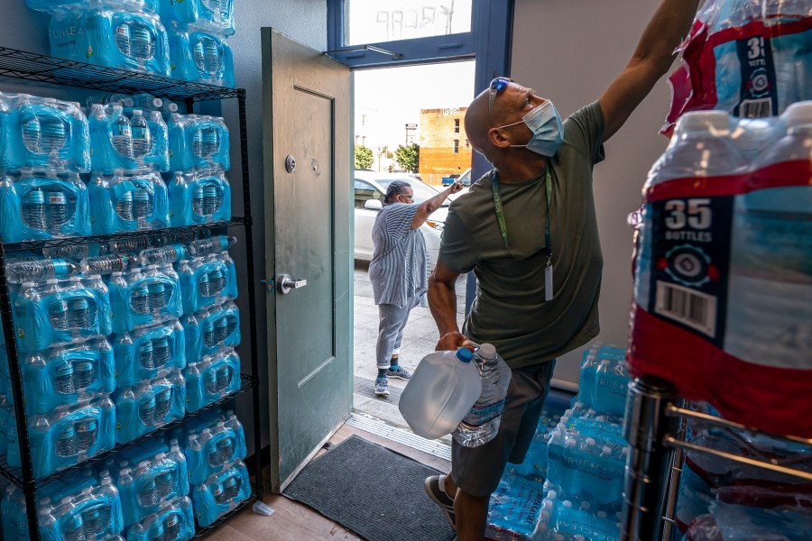 FILE - Chris Cowan with Cascadia Behavioral Healthcare's street outreach team loads water and other cooling supplies before visiting homeless camps, Aug. 12, 2021, in Portland, Ore. (AP Photo/Nathan Howard, File)