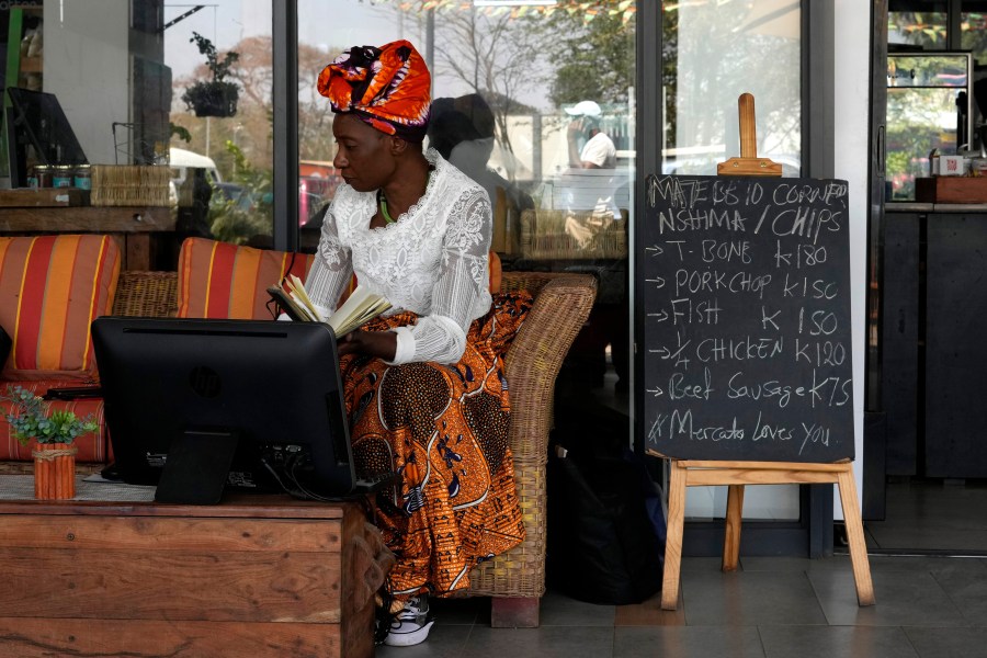 Edla Musonda works on her desktop computer at Mercato Cafe in Lusaka, Zambia, Tuesday, Sept. 17, 2024. (AP Photo/Themba Hadebe)