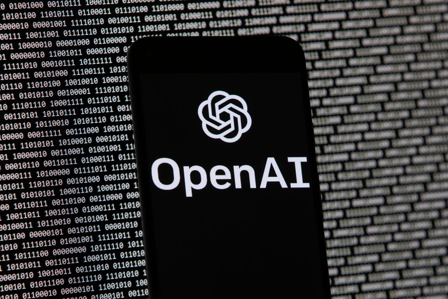 FILE - The OpenAI logo appears on a mobile phone in front of a computer screen with random binary data, March 9, 2023, in Boston. (AP Photo/Michael Dwyer, File)