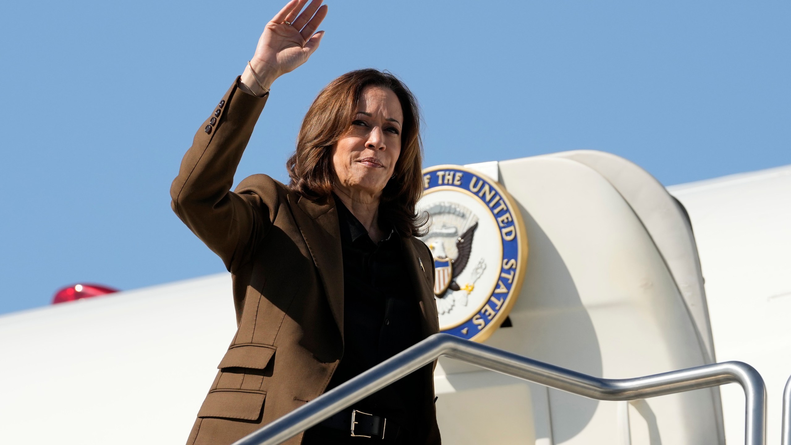 Democratic presidential nominee Vice President Kamala Harris waves as she boards Air Force Two, Friday, Oct. 11, 2024, at Sky Harbor International Airport in Phoenix, en route to Washington. (AP Photo/Ross D. Franklin)