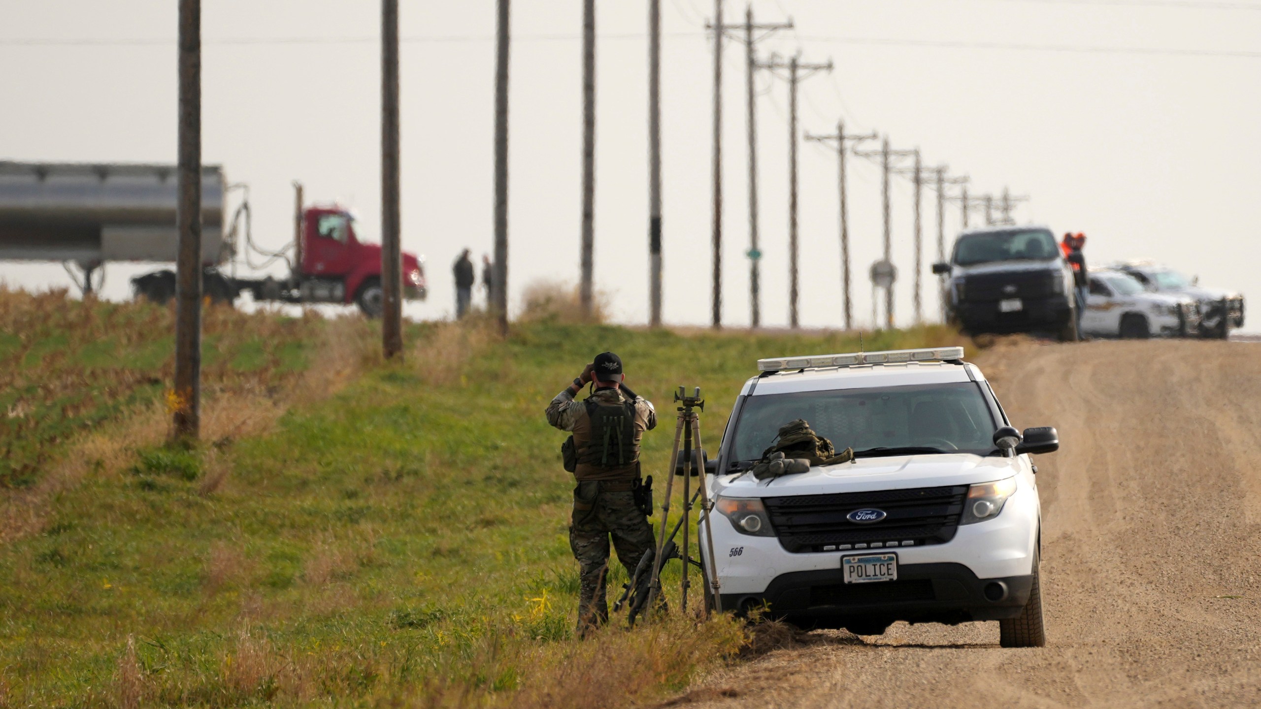 Local police and Secret Service agents surround the area as Tim Walz, Minnesota governor and Democratic vice presidential candidate, takes part in the annual Minnesota Governor's Pheasant Hunting Opener near Sleepy Eye, Minn., Saturday, Oct. 12, 2024. (Anthony Souffle/Star Tribune via AP)