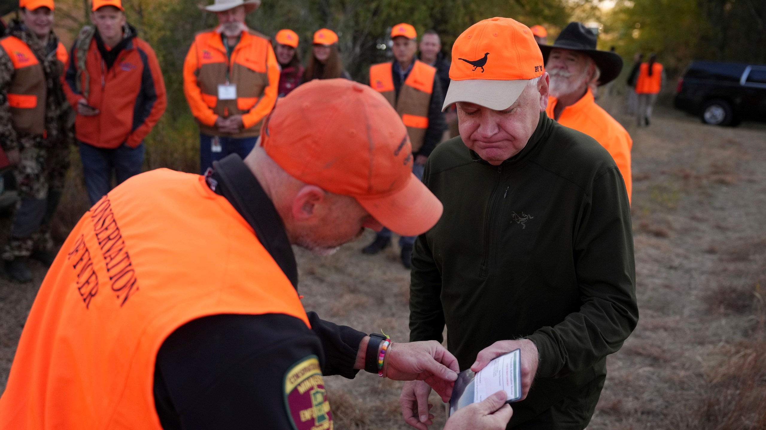 Tim Walz, Minnesota governor and Democratic vice presidential candidate, gets his hunting license ceremoniously inspected before heading out for the annual Minnesota Governor's Pheasant Hunting Opener near Sleepy Eye, Minn., Saturday, Oct. 12, 2024. (Anthony Souffle/Star Tribune via AP)