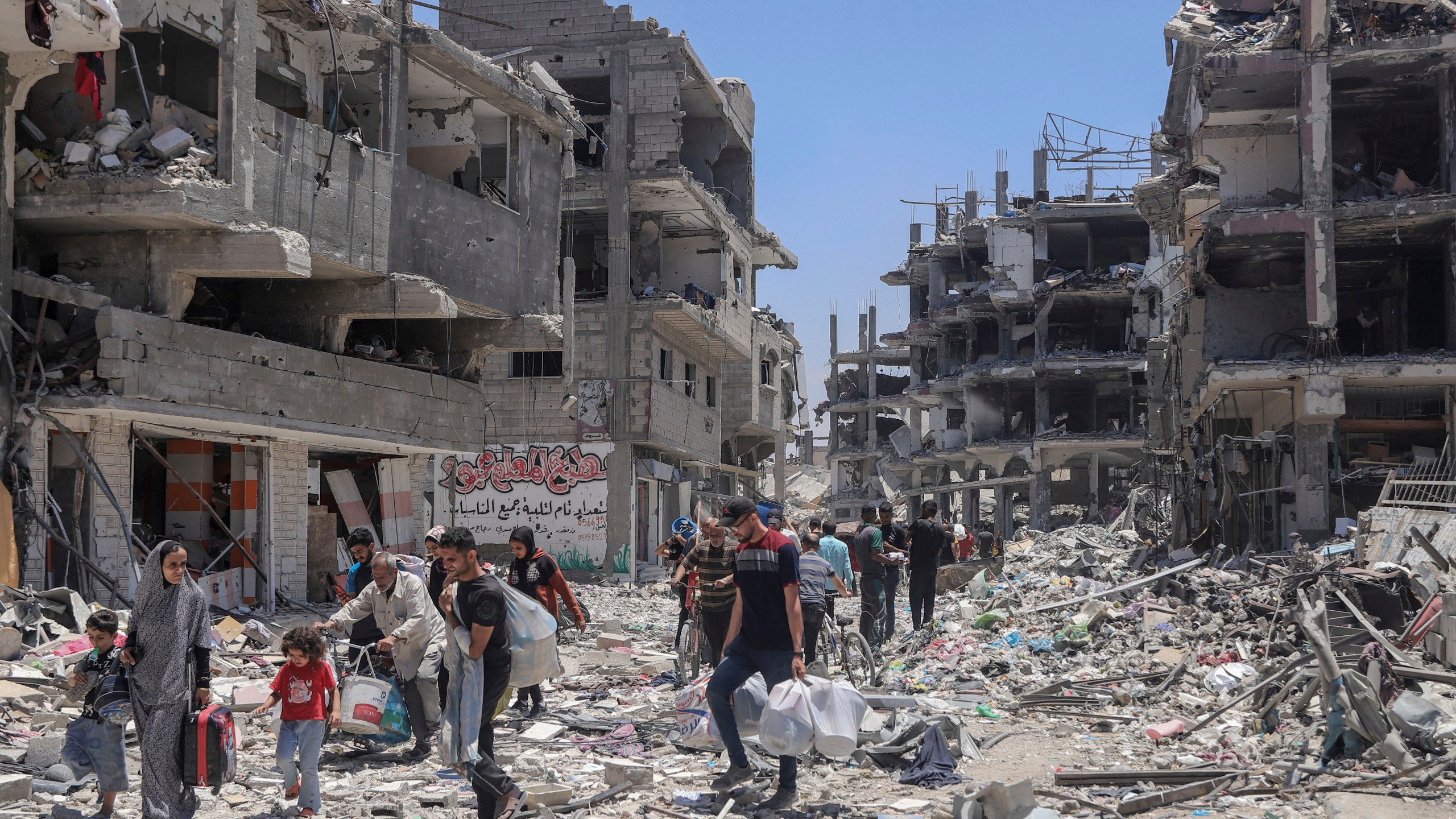 FILE - Palestinians walk through the destruction in the wake of an Israeli air and ground offensive in Jebaliya, northern Gaza Strip, on May 30, 2024. (AP Photo/Enas Rami, File)