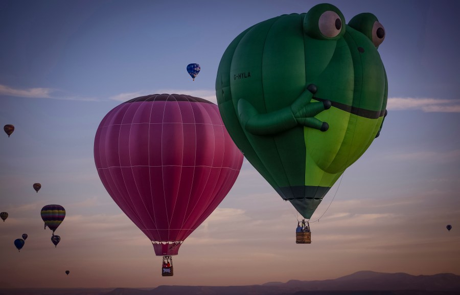 Balloons sail in the sky captured during flight in Meow Wolf's Skyworm hot air balloon during the Albuquerque International Balloon Fiesta at Balloon Fiesta Park in Albuquerque, N.M., on Tuesday, Oct. 8, 2024.v. (Chancey Bush/The Albuquerque Journal via AP)