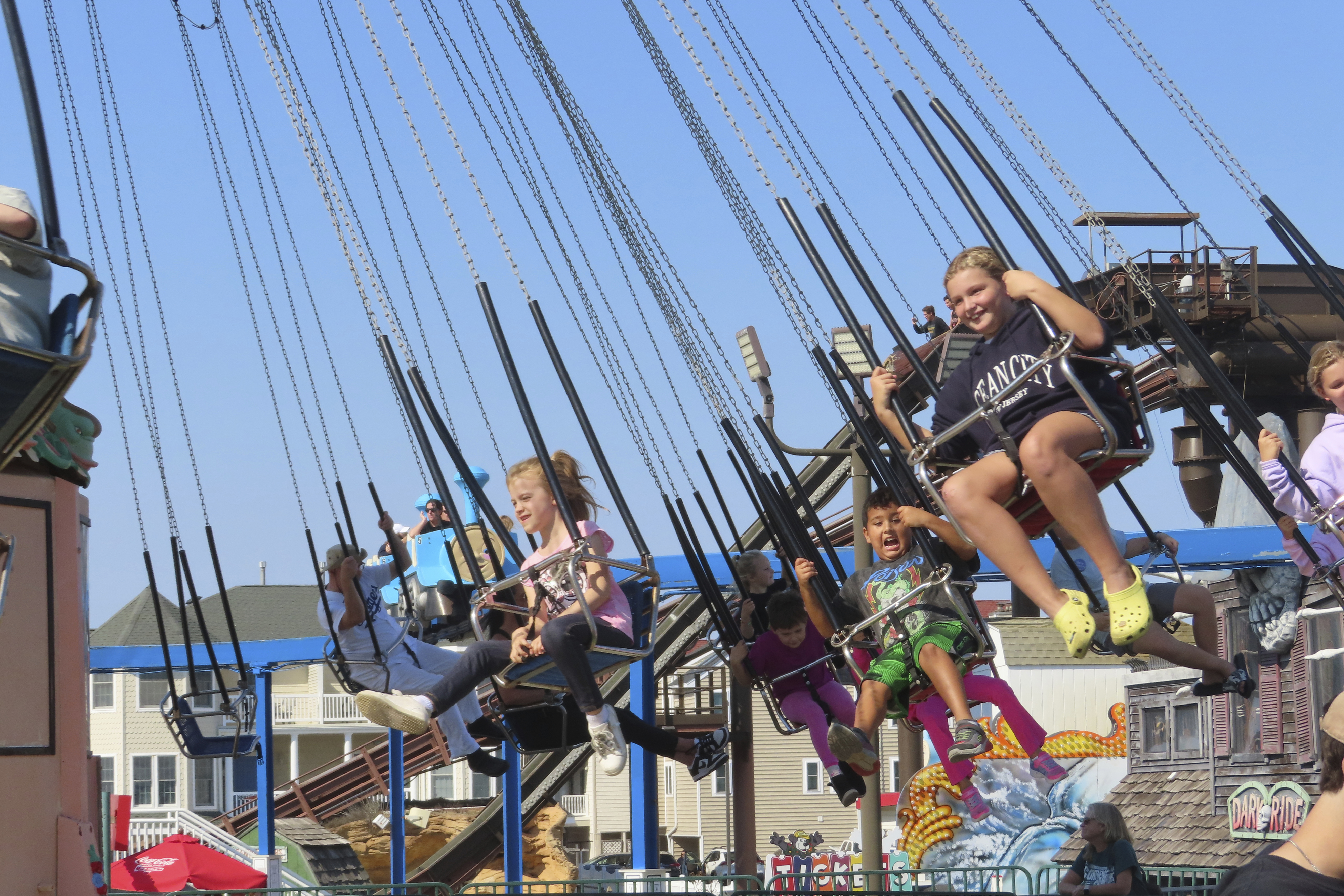 People ride the flying chair attraction at Gillian's Wonderland, the popular amusement park on the boardwalk in Ocean City, N.J., during its final day of operation before shutting down for good, Sunday, Oct. 13, 2024. (AP Photo/Wayne Parry)