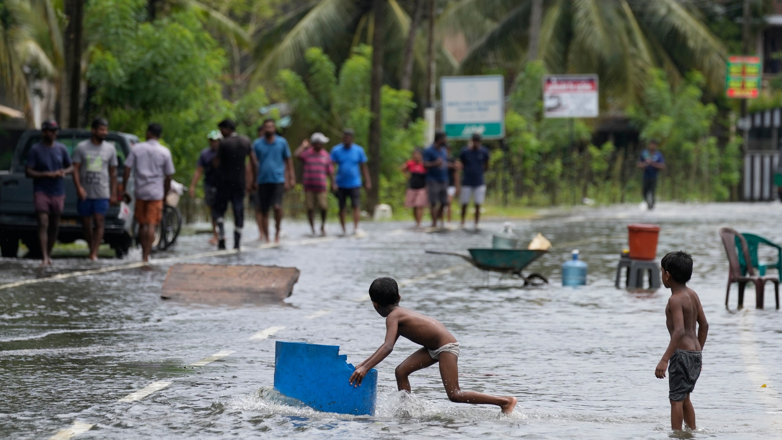 Children play in a flooded street in Colombo, Sri Lanka, Sunday, Oct. 13, 2024. (AP Photo/Eranga Jayawardena)