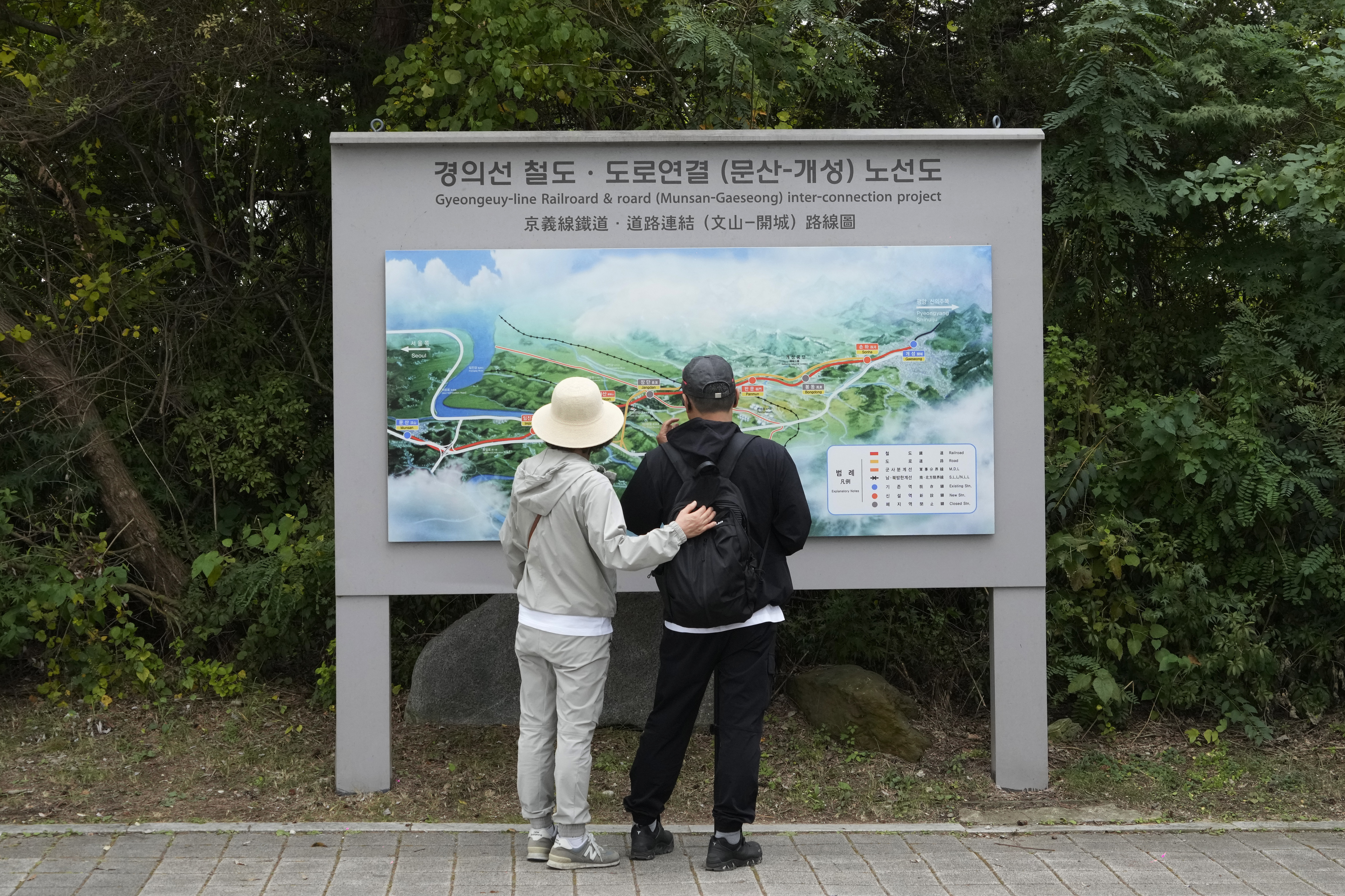 South Korean visitors look at a map which shows a border area of two Koreas with a railroad line between Munsan city in south and Kaesong in north, at the Imjingak Pavilion in Paju, South Korea, near the border with North Korea, Monday, Oct. 14, 2024. (AP Photo/Ahn Young-joon)