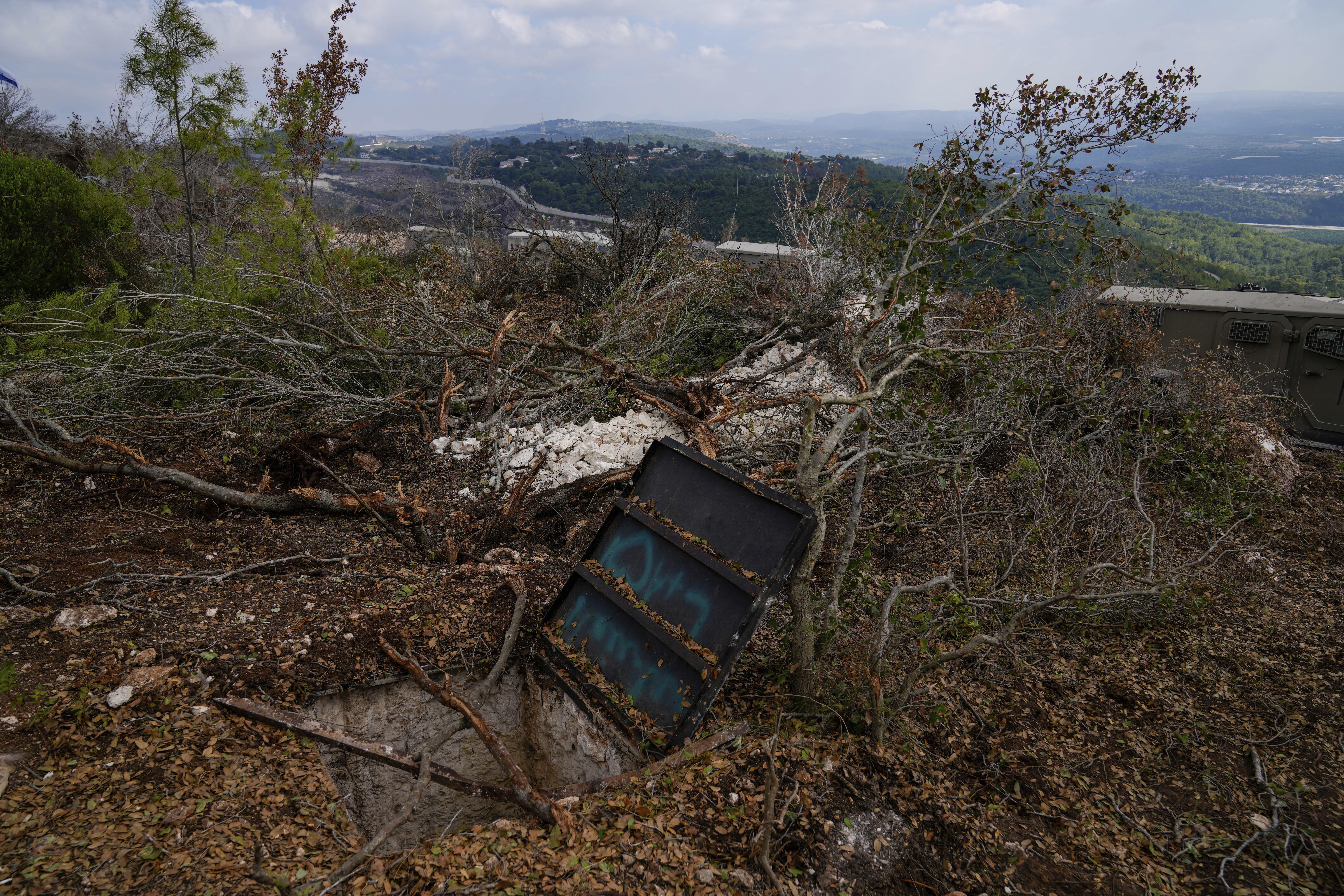 Israeli soldiers display what they say is an entrance to a Hezbollah tunnel found during their ground operation in southern Lebanon, near the border with Israel, Sunday, Oct. 13, 2024. (AP Photo/Sam McNeil)