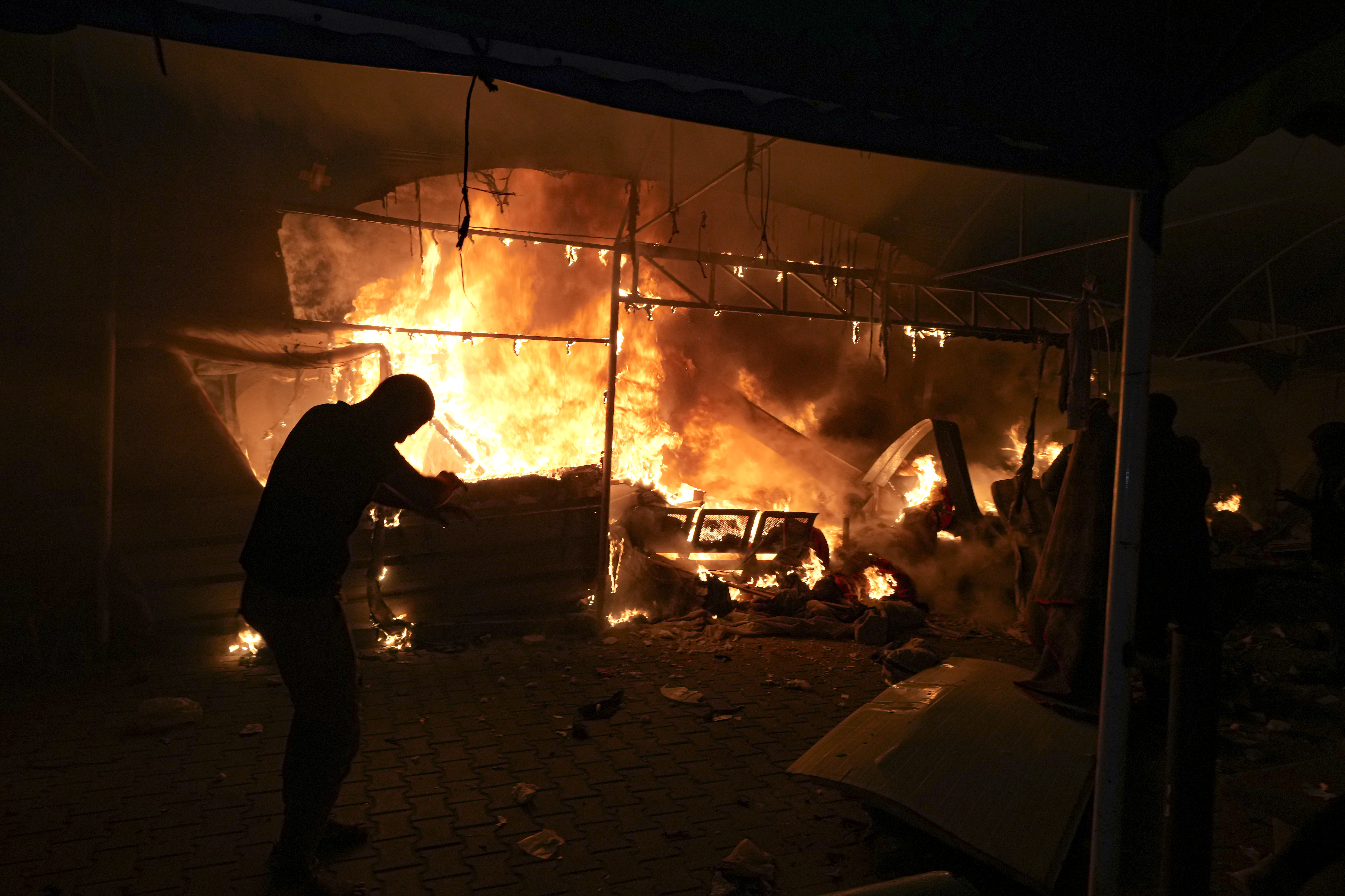 Palestinians react to a fire after an Israeli strike hit a tent area in the courtyard of Al Aqsa Martyrs hospital in Deir al Balah, Gaza Strip, Monday, Oct. 14, 2024. (AP Photo/Abdel Kareem Hana)