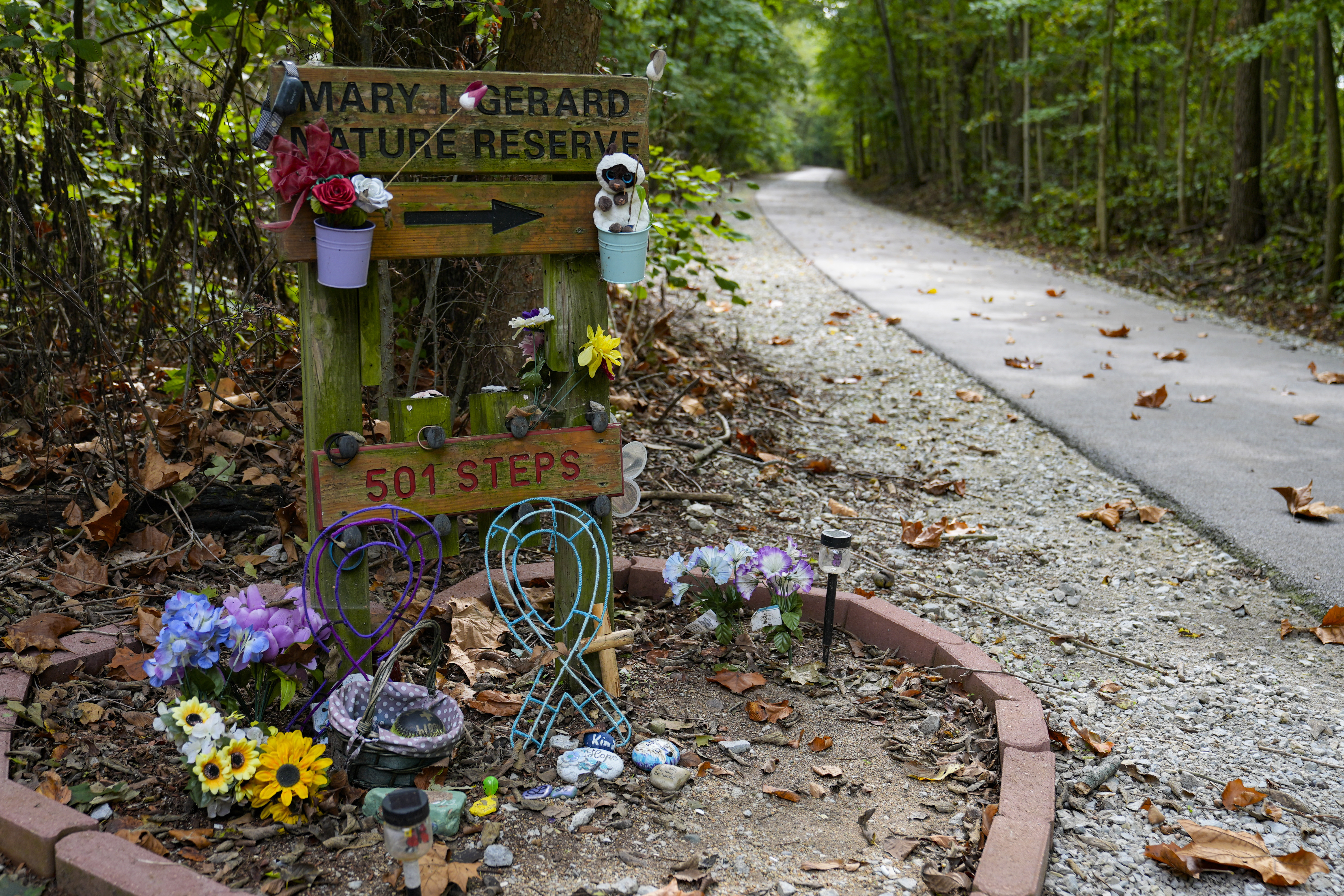 Decorated stones bearing the names of Abigail Williams and Liberty German, who were killed in February 2017, are placed at a memorial along the Monon High Bridge Trail in Delphi, Ind., Tuesday, Oct. 1, 2024. (AP Photo/Michael Conroy)