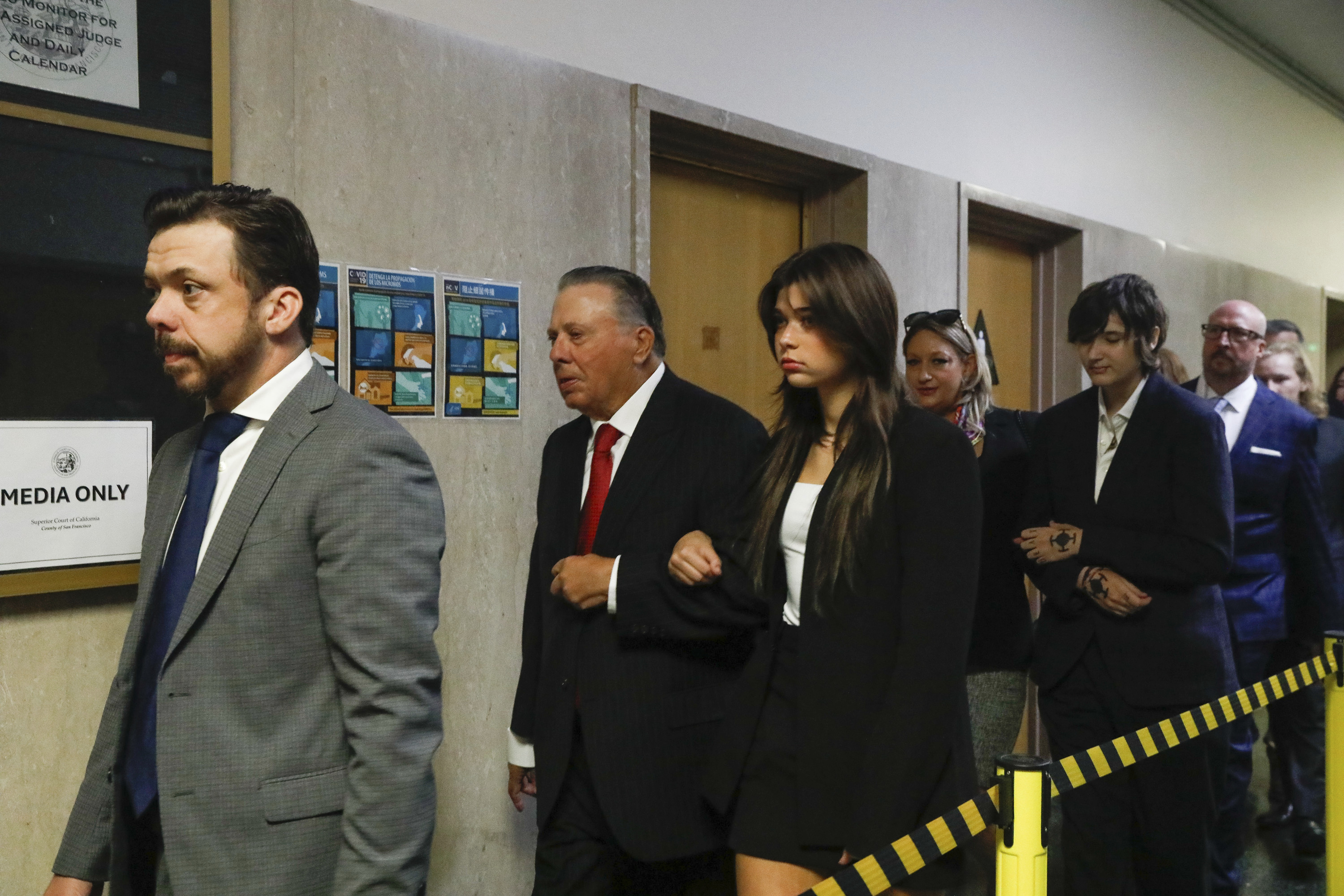 Tim Oliver Lee, left, brother of Cash App founder Bob Lee, Rick Lee, second left, father of Bob Lee; Krista Lee, fourth left, ex-wife of Bob Lee, and other family members of Bob Lee walk to Department 28 to enter the courtroom at the Hall of Justice on the first day of the murder trial of Nima Momeni, Monday, Oct. 14, 2024 in San Francisco. (Lea Suzuki/San Francisco Chronicle via AP)