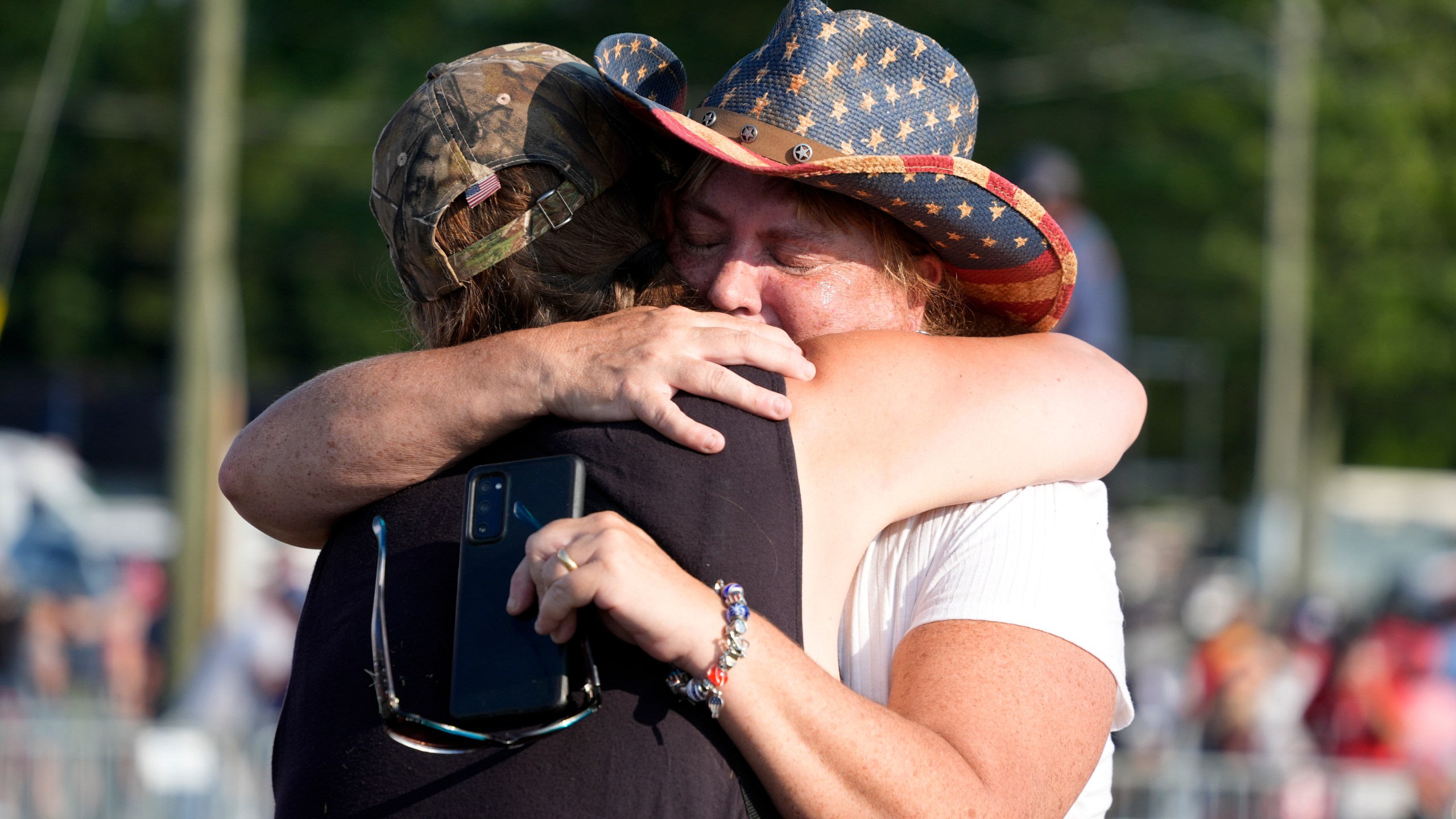 FILE - People hug after Republican presidential candidate former President Donald Trump was helped off the stage at a campaign event in Butler, Pa., July 13, 2024. (AP Photo/Gene J. Puskar, File)