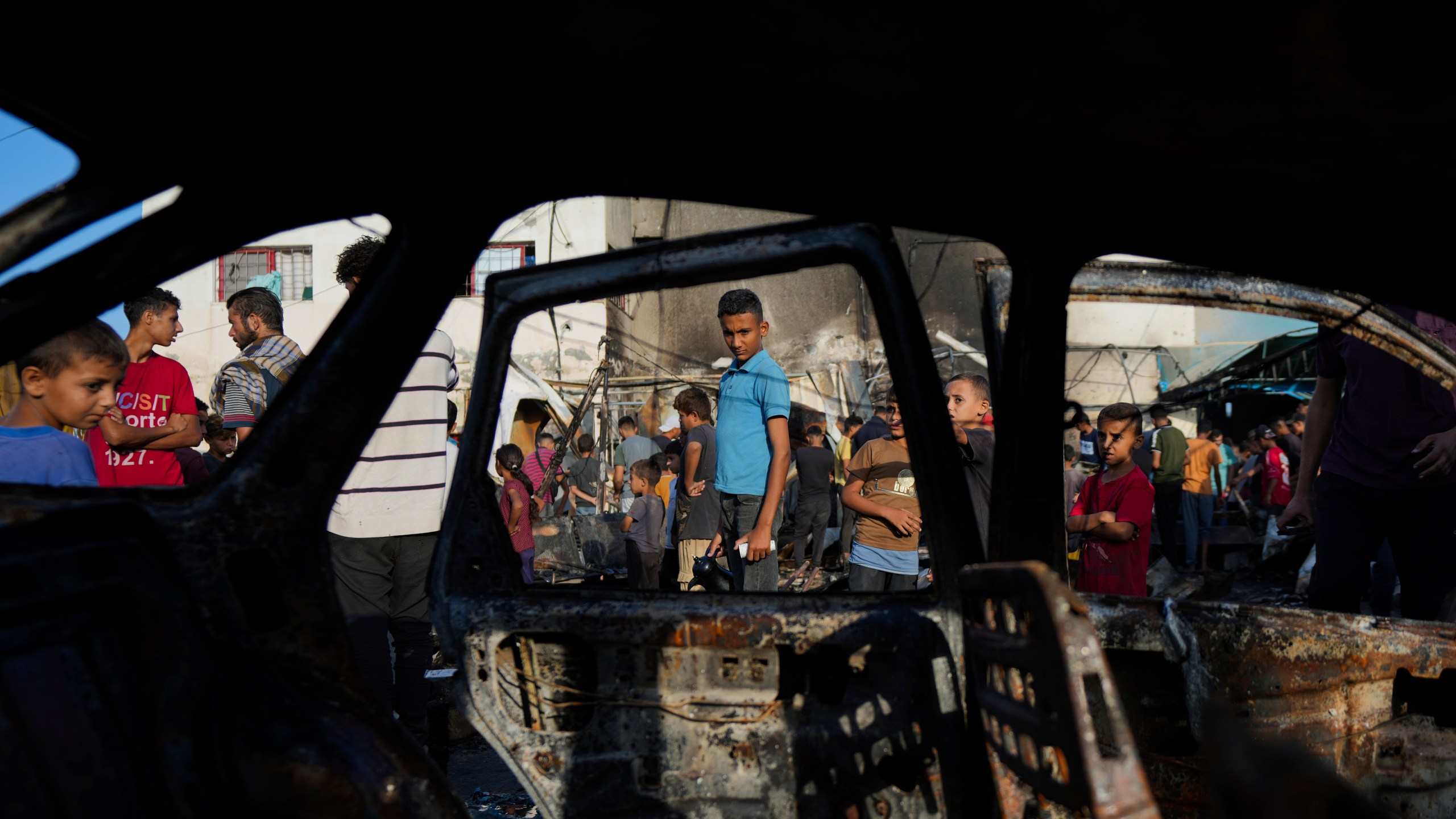 Palestinians look at the damage after an Israeli strike hit a tent area in the courtyard of Al Aqsa Martyrs hospital in Deir al Balah, Gaza Strip, Monday, Oct. 14, 2024. (AP Photo/Abdel Kareem Hana)