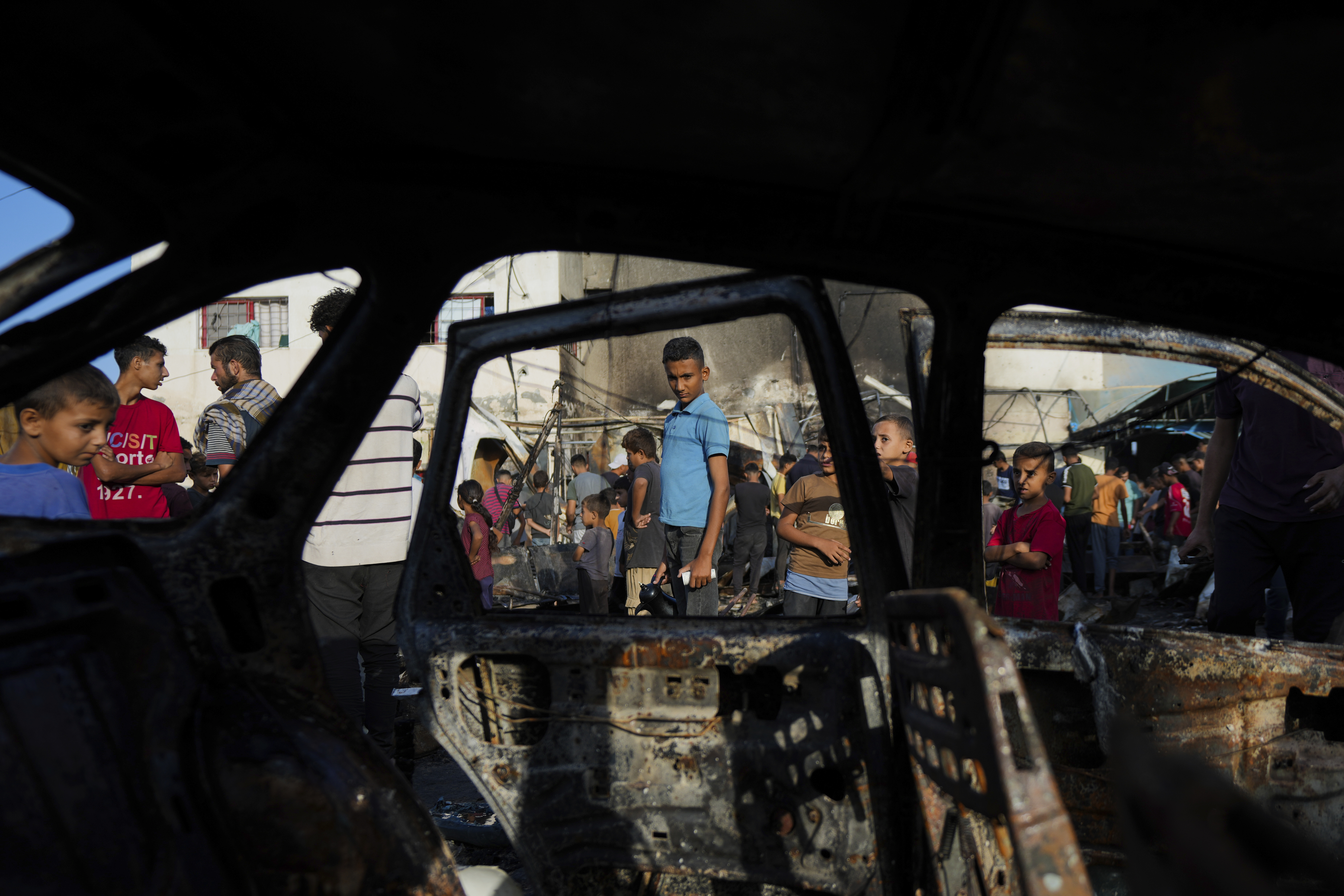 Palestinians look at the damage after an Israeli strike hit a tent area in the courtyard of Al Aqsa Martyrs hospital in Deir al Balah, Gaza Strip, Monday, Oct. 14, 2024. (AP Photo/Abdel Kareem Hana)