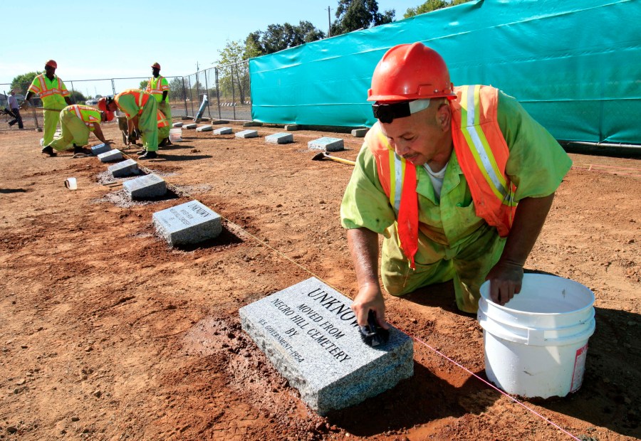 FILE - Steven Abujen, a California prison inmate with the Prison Industry Authority, cleans one of the newly installed headstones at the Mormon Island Relocation Cemetery, near Folsom, Calif., on Oct. 18, 2011. (AP Photo/Rich Pedroncelli, File)