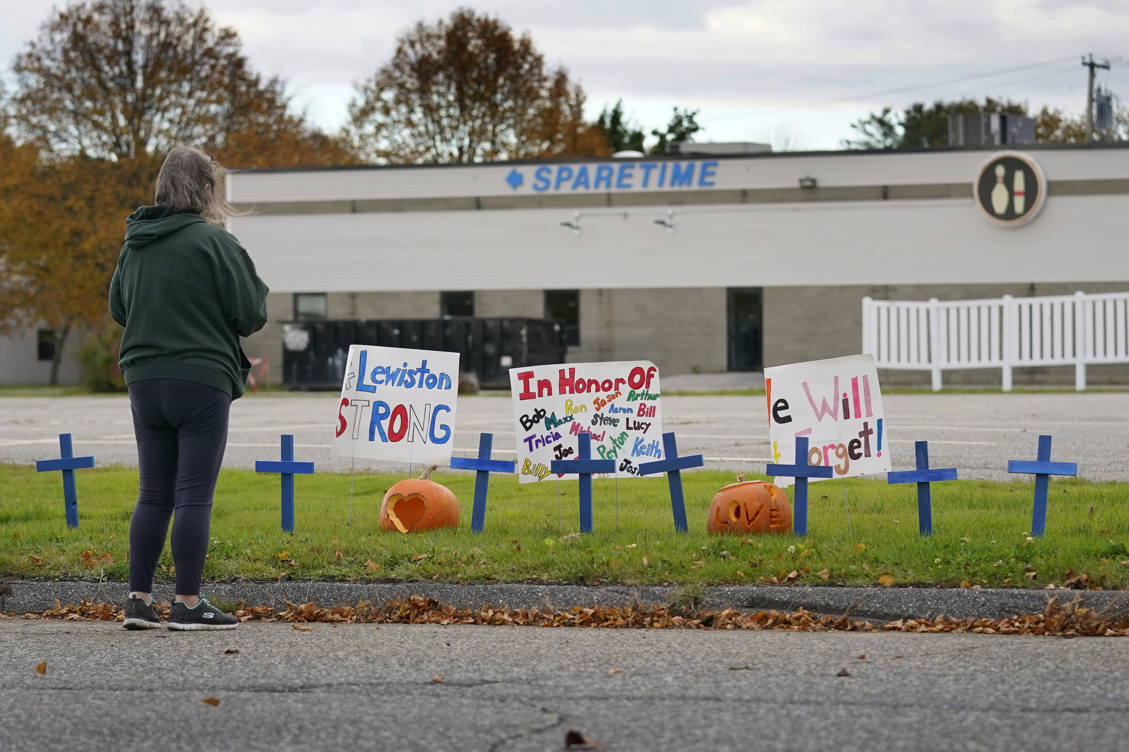 FILE - A woman visits a makeshift memorial outside Sparetime Bowling Alley, the site of a mass shooting, Oct. 28, 2023, in Lewiston, Maine. (AP Photo/Robert F. Bukaty, File)