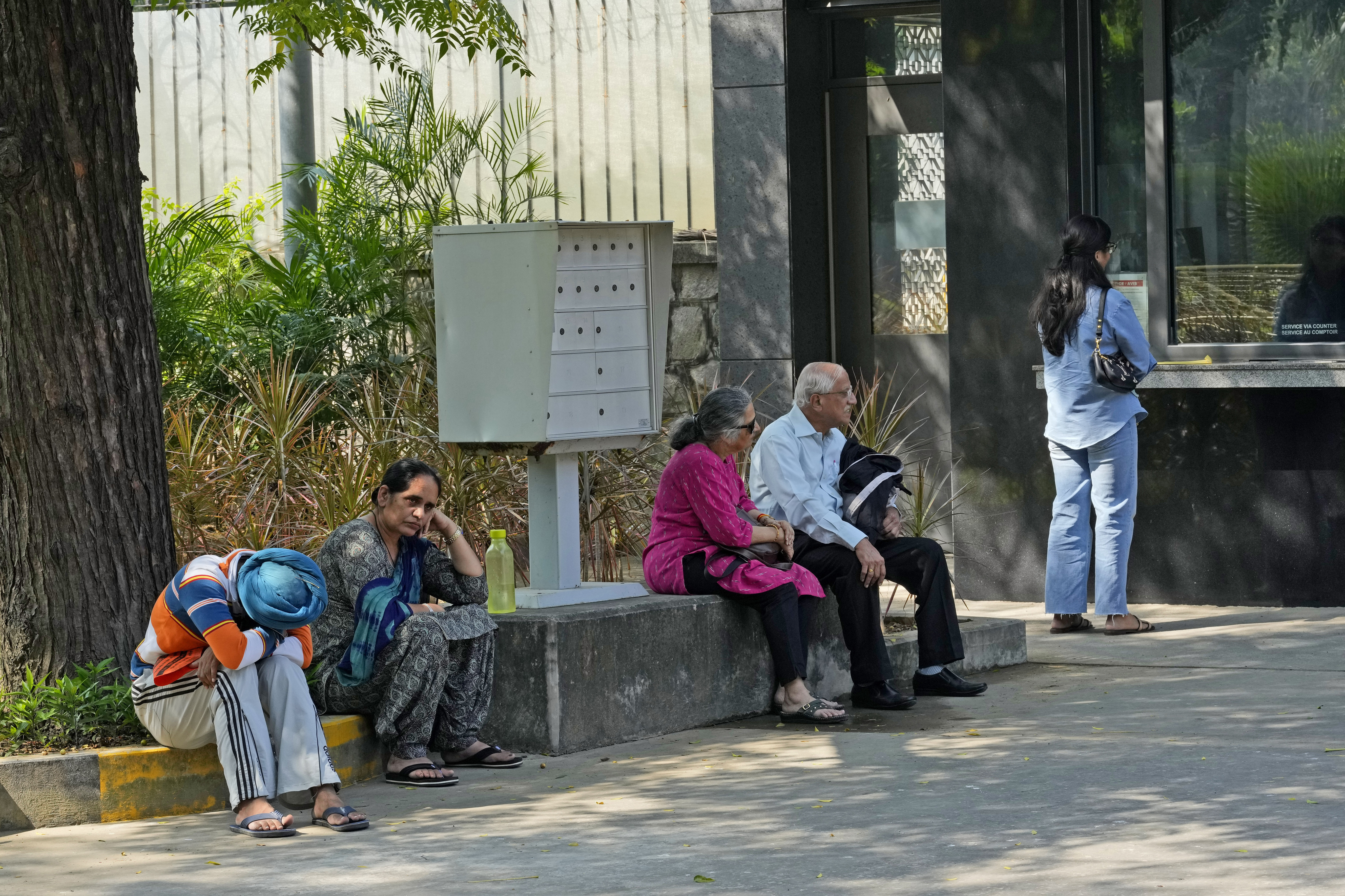 People wait outside the Canadian high commission in New Delhi, India, Tuesday, Oct. 15, 2024 after India and Canada expelled each other’s top diplomats over an ongoing dispute about the killing of a Sikh activist in Canada. (AP Photo/Manish Swarup)