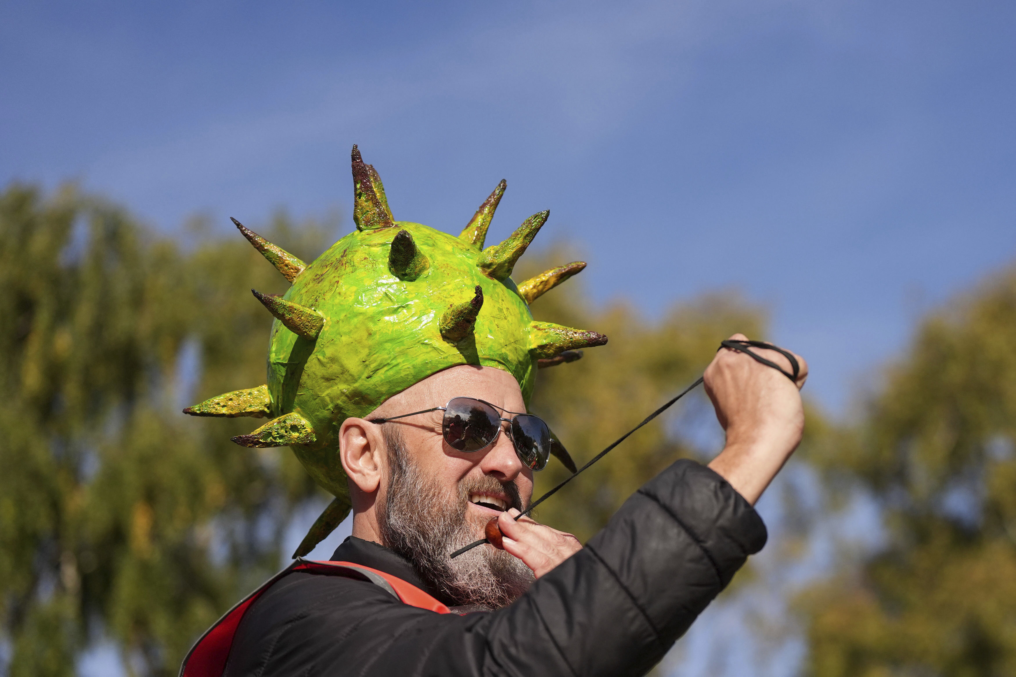 Competitor Neil Morbey wearing a conker themed hat takes part in the annual World Conker Championships at the Shuckburgh Arms in Southwick, Peterborough, England, Sunday Oct. 13, 2024. (Jacob King/PA via AP)