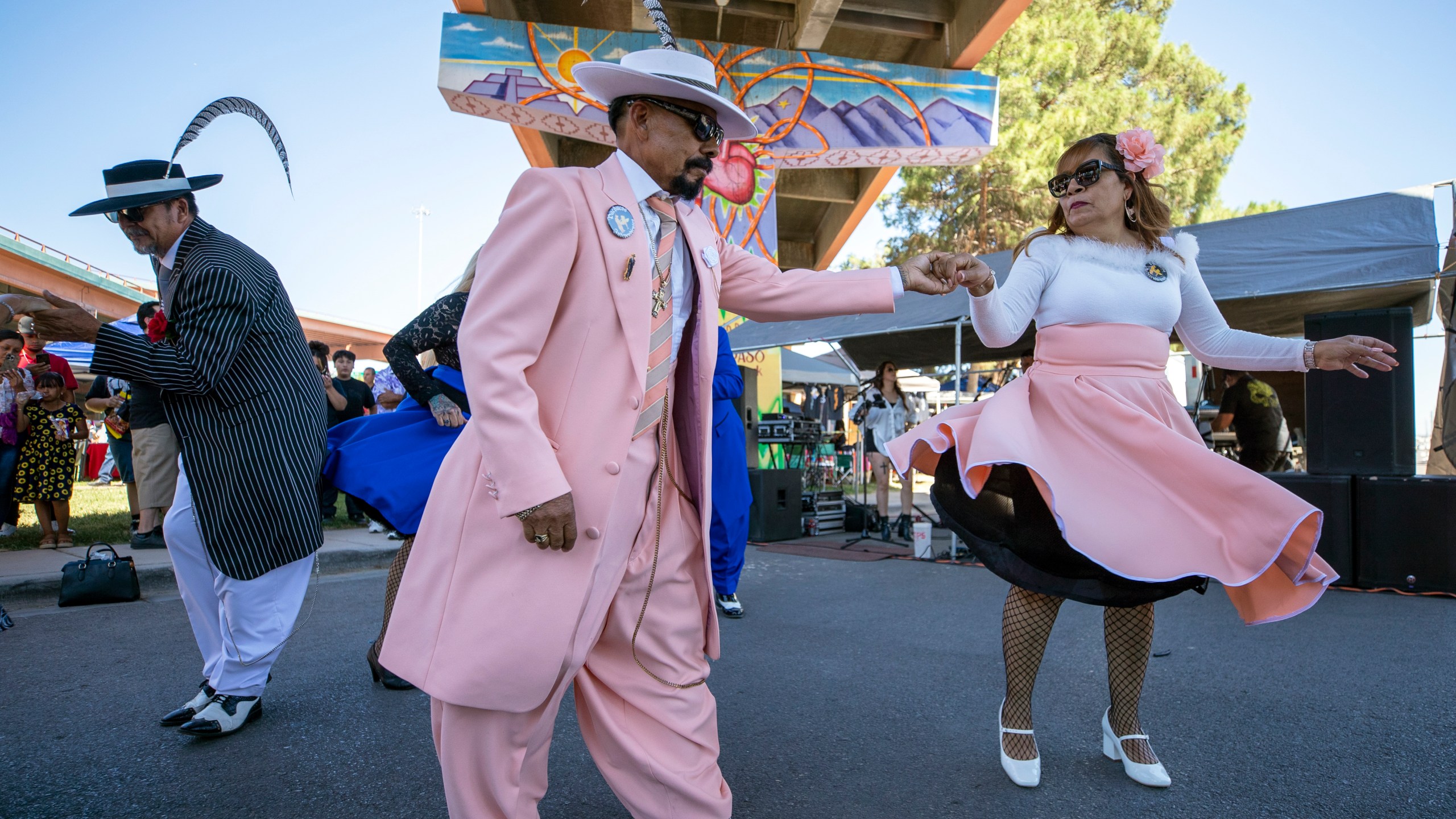 Hugo Cardenas and Araceli Martinez, wearing Zoot suits of the Mexican American subculture known as Pachucos, dance while attending a lowrider exhibition during the 20th anniversary of Lincoln Park in El Paso, Texas, Sunday, Sept. 22, 2024. (AP Photo/Andrés Leighton)