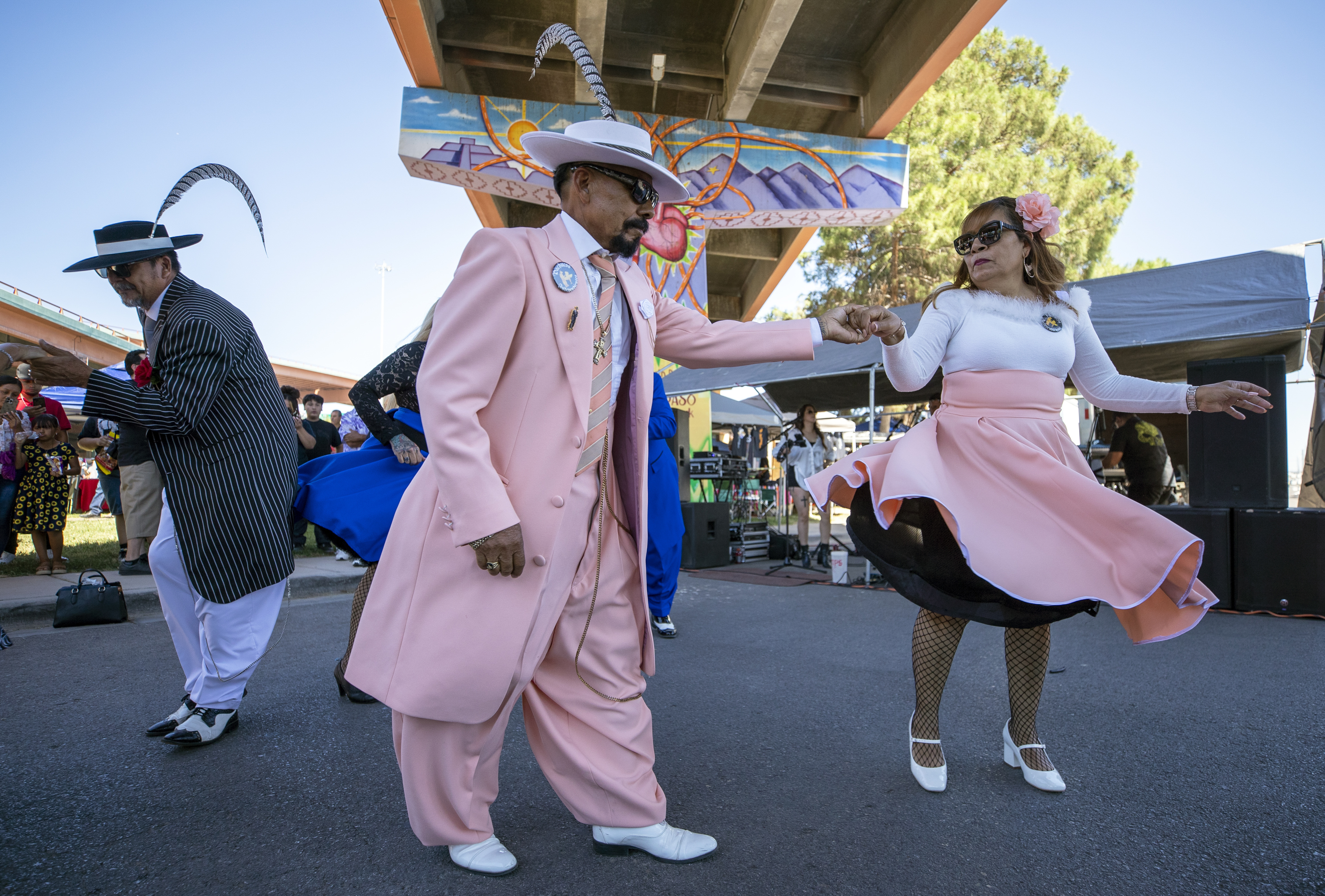 Hugo Cardenas and Araceli Martinez, wearing Zoot suits of the Mexican American subculture known as Pachucos, dance while attending a lowrider exhibition during the 20th anniversary of Lincoln Park in El Paso, Texas, Sunday, Sept. 22, 2024. (AP Photo/Andrés Leighton)