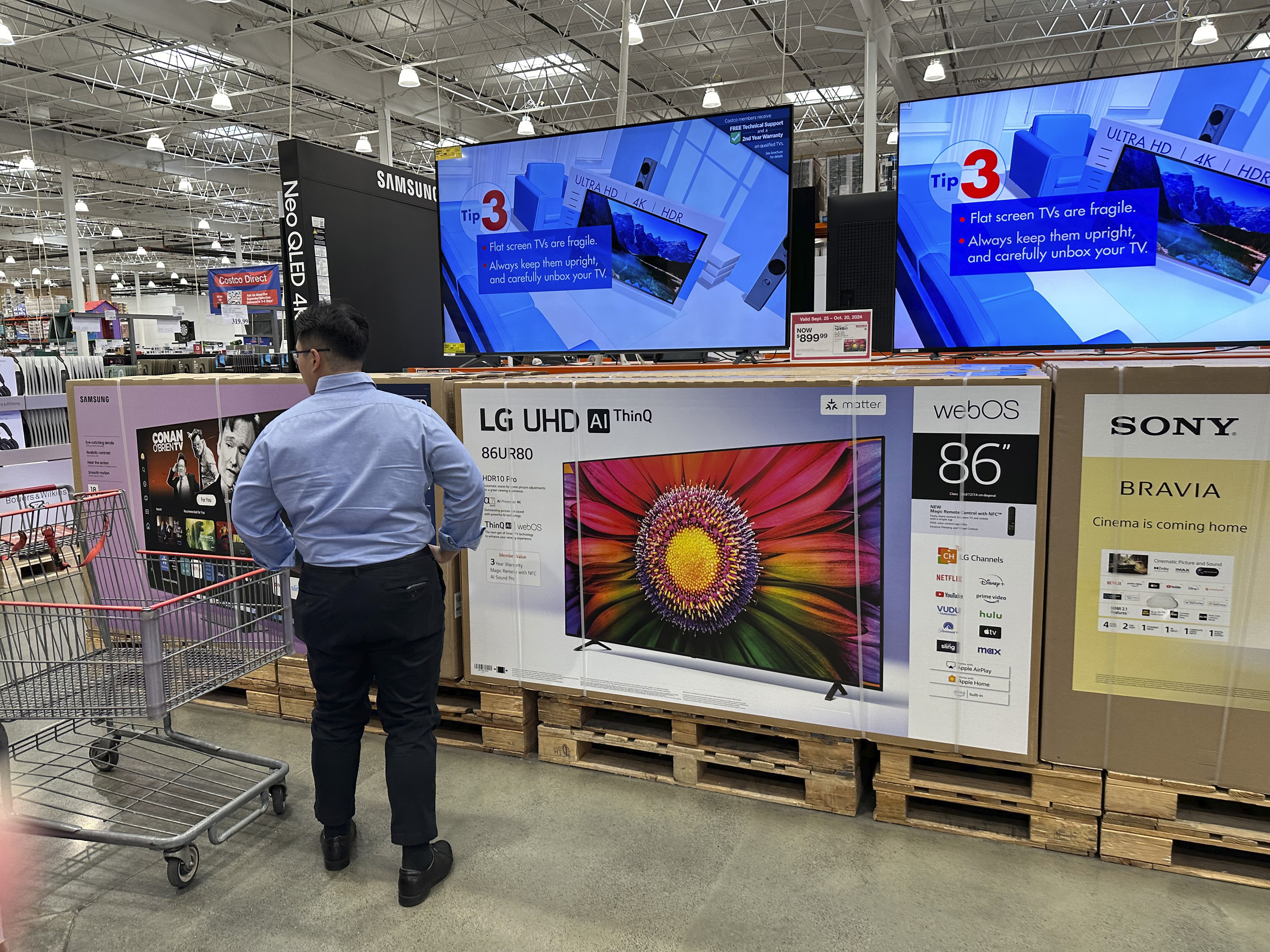 FILE - A shopper considers large-screen televisions on display in a Costco warehouse Oct. 3, 2024, in Timnath, Colo. (AP Photo/David Zalubowski, File)