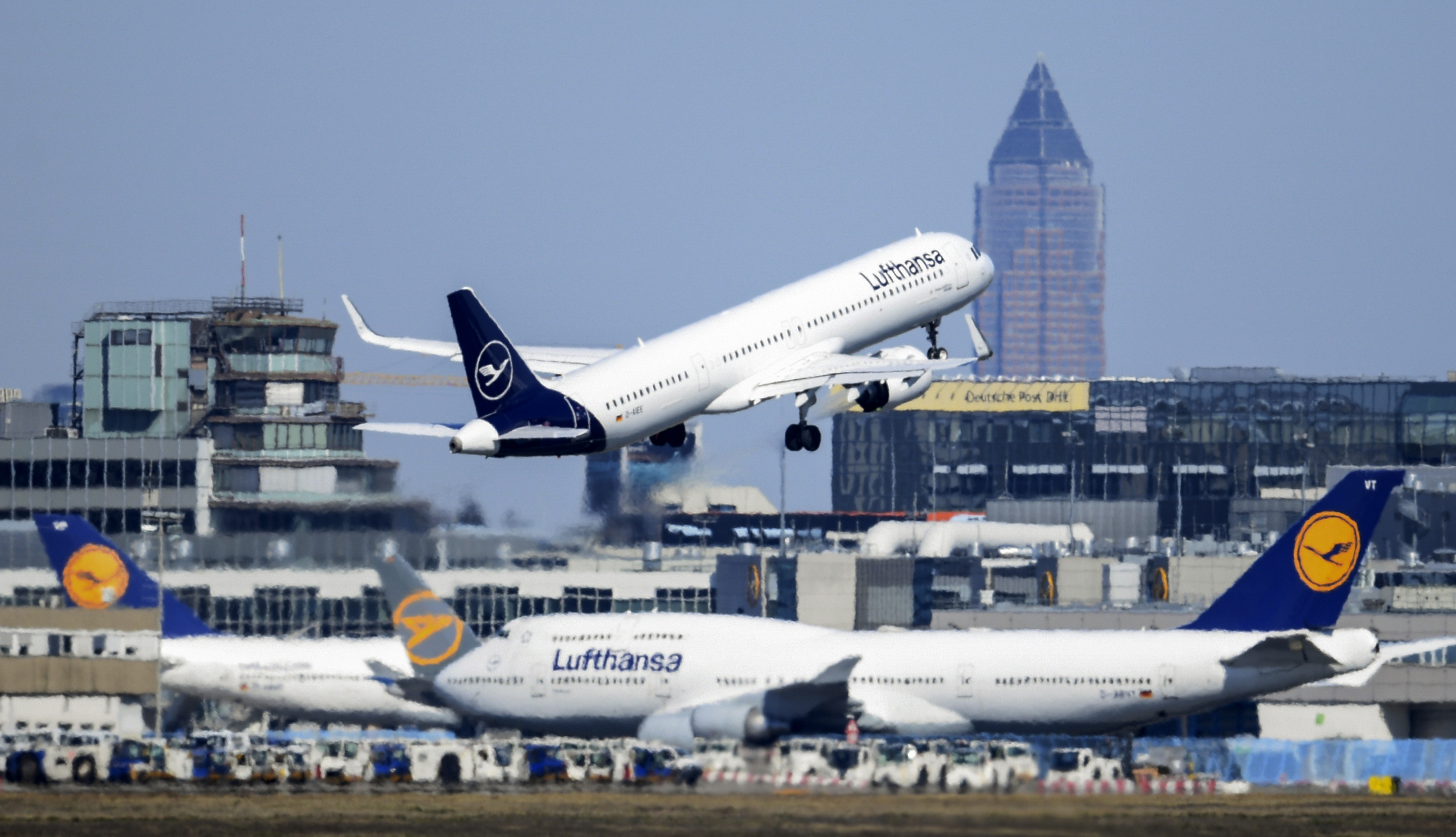 FILE - A Lufthansa Airbus takes off at Frankfurt Airport above other passenger aircraft of the airline, Germany, Monday, March 23, 2020. (Arne Dedert/dpa via AP, File)