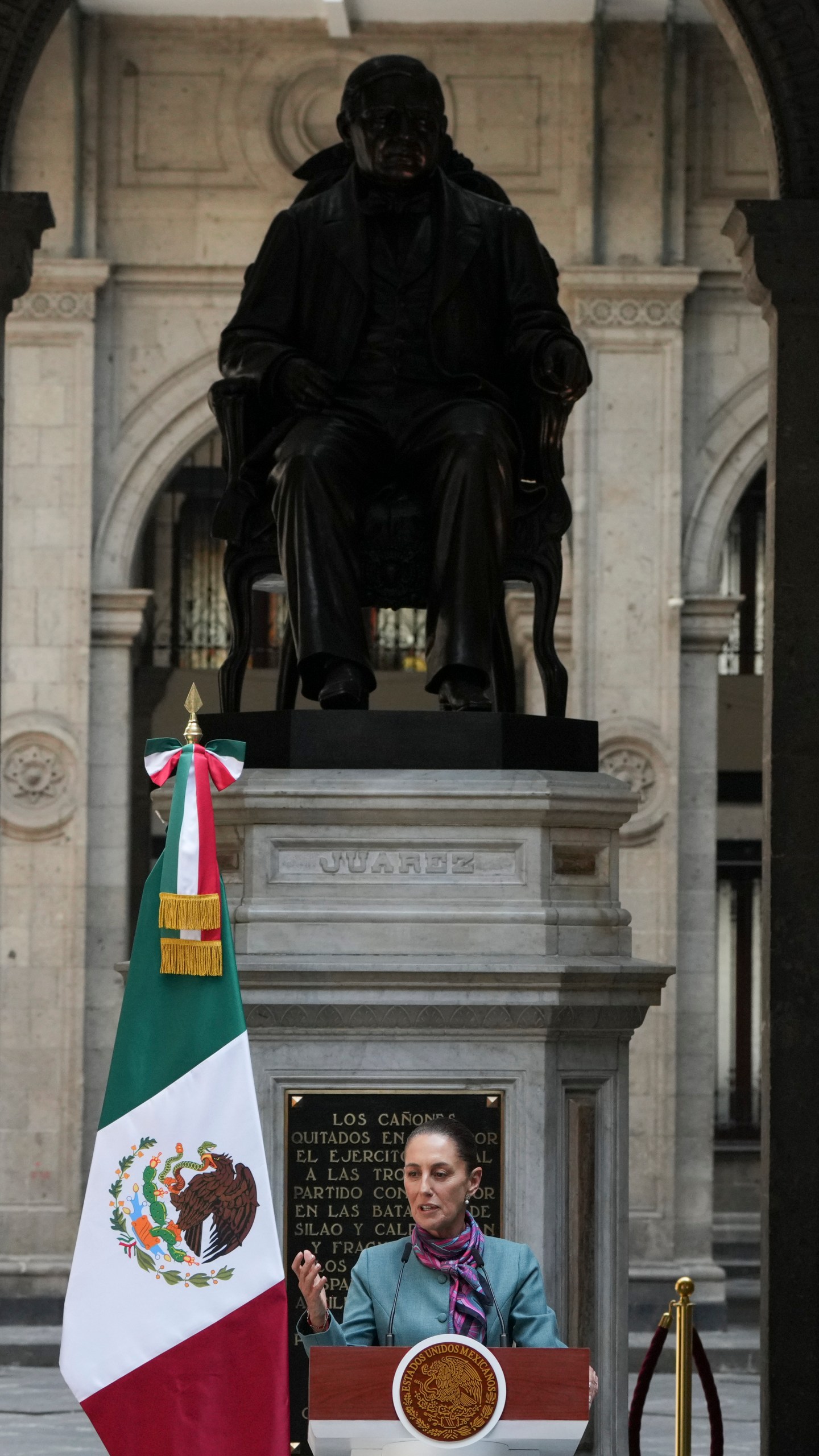 Mexican President Claudia Sheinbaum gives a news conference at the National palace in Mexico City, Tuesday, Oct. 15, 2024. The statue is of former Mexican President Benito Juarez. (AP Photo/Fernando Llano)