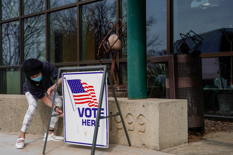 FILE- Poll worker Pranee Sheskey puts up a sign outside the Warner Park Community Recreation Center for the first day of early voting Tuesday, March 21, 2023, in Madison, Wis. (AP Photo/Morry Gash, File)